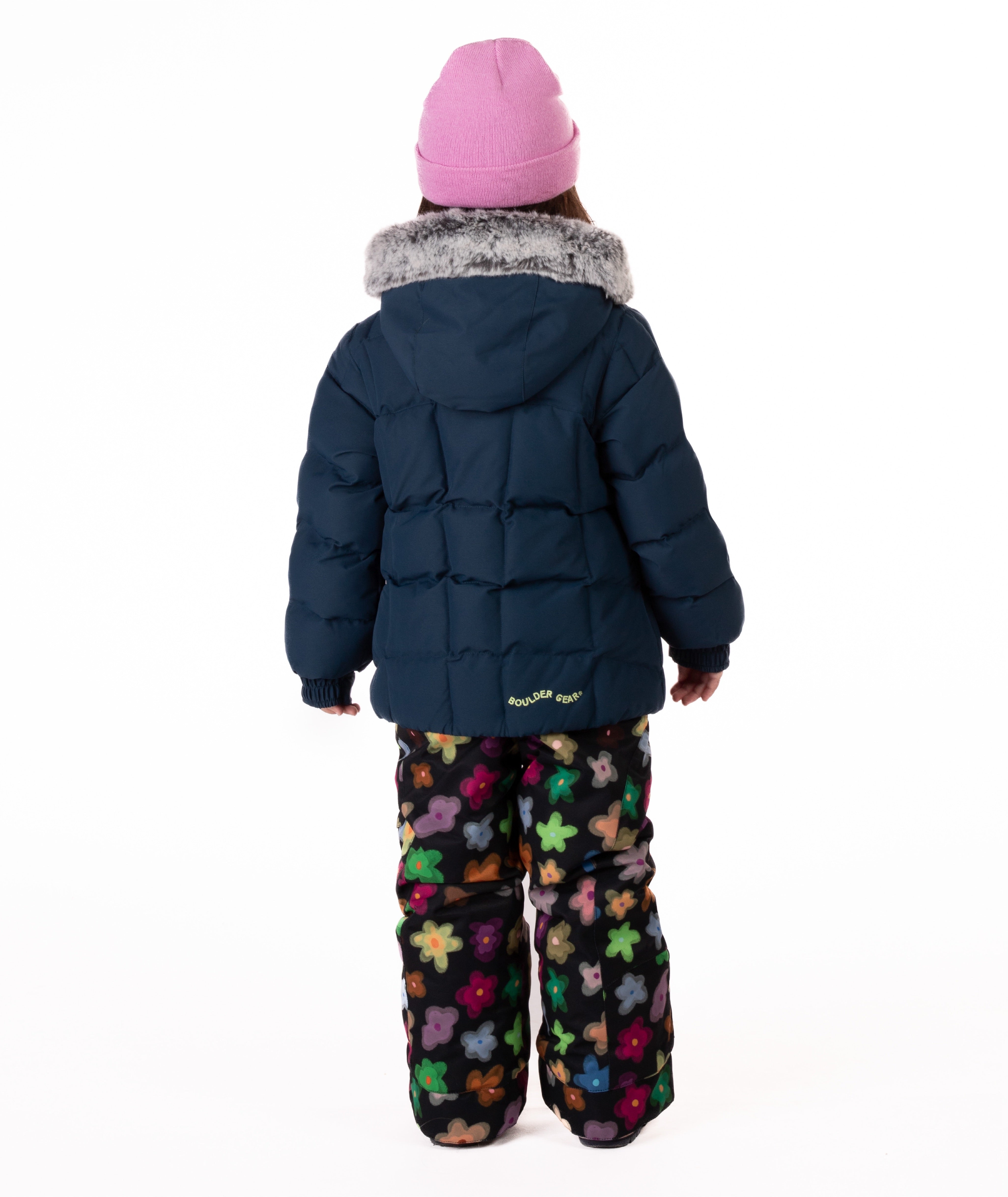 Child wearing a navy blue quilted puffy winter coat on a white background