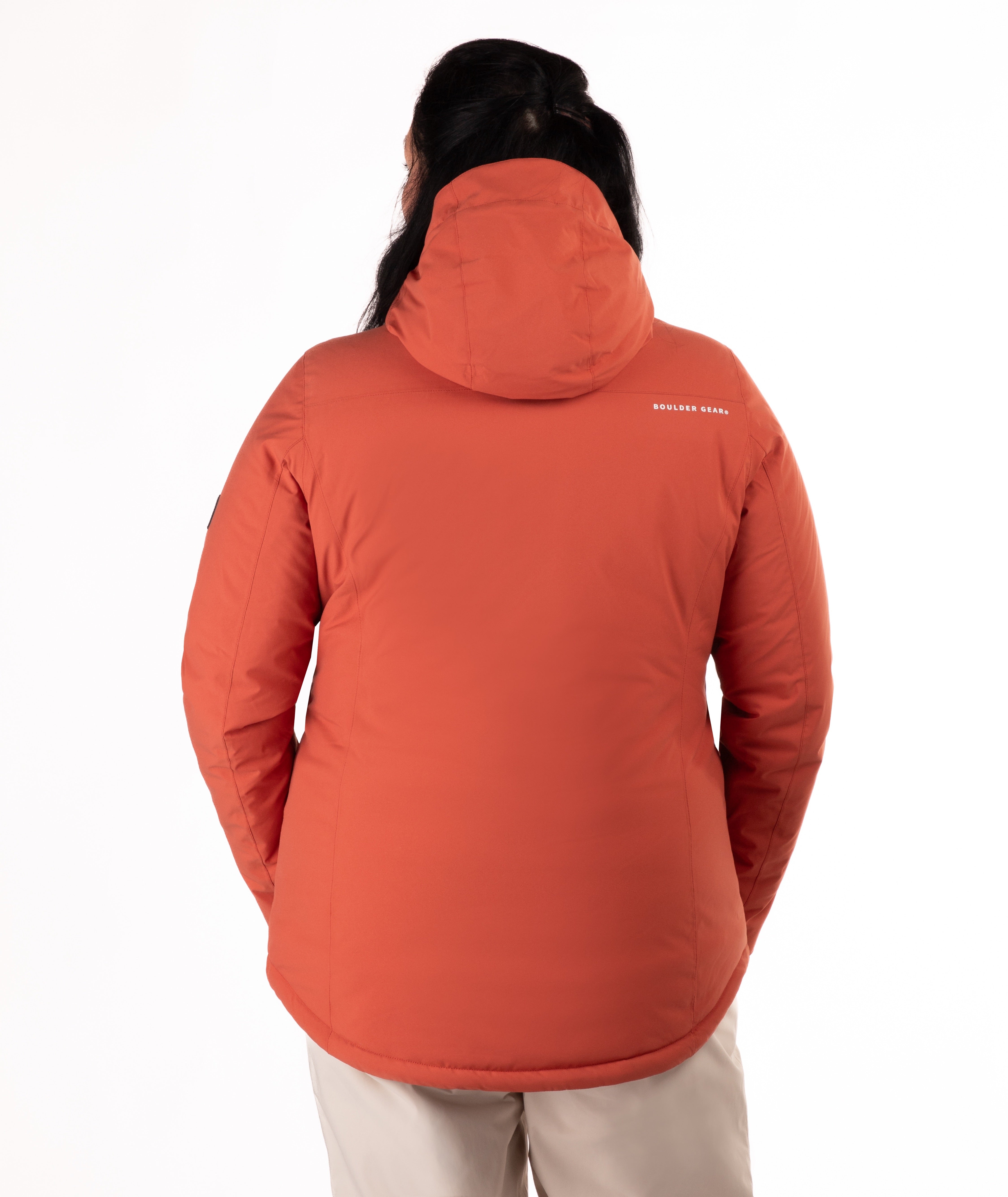 back of woman wearing a rust colored winter jacket on a white background