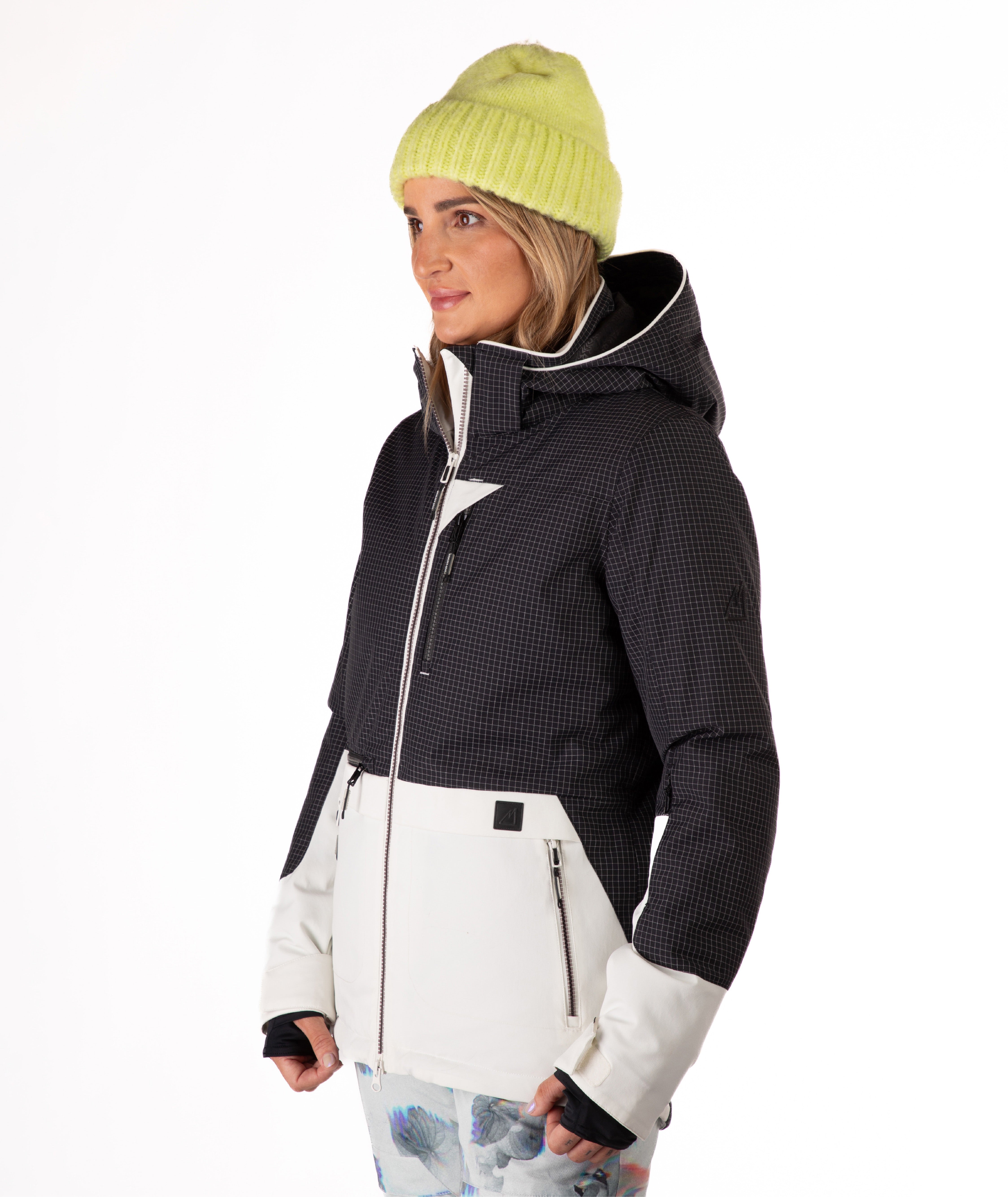 Person wearing a two-tone black and white jacket a white background