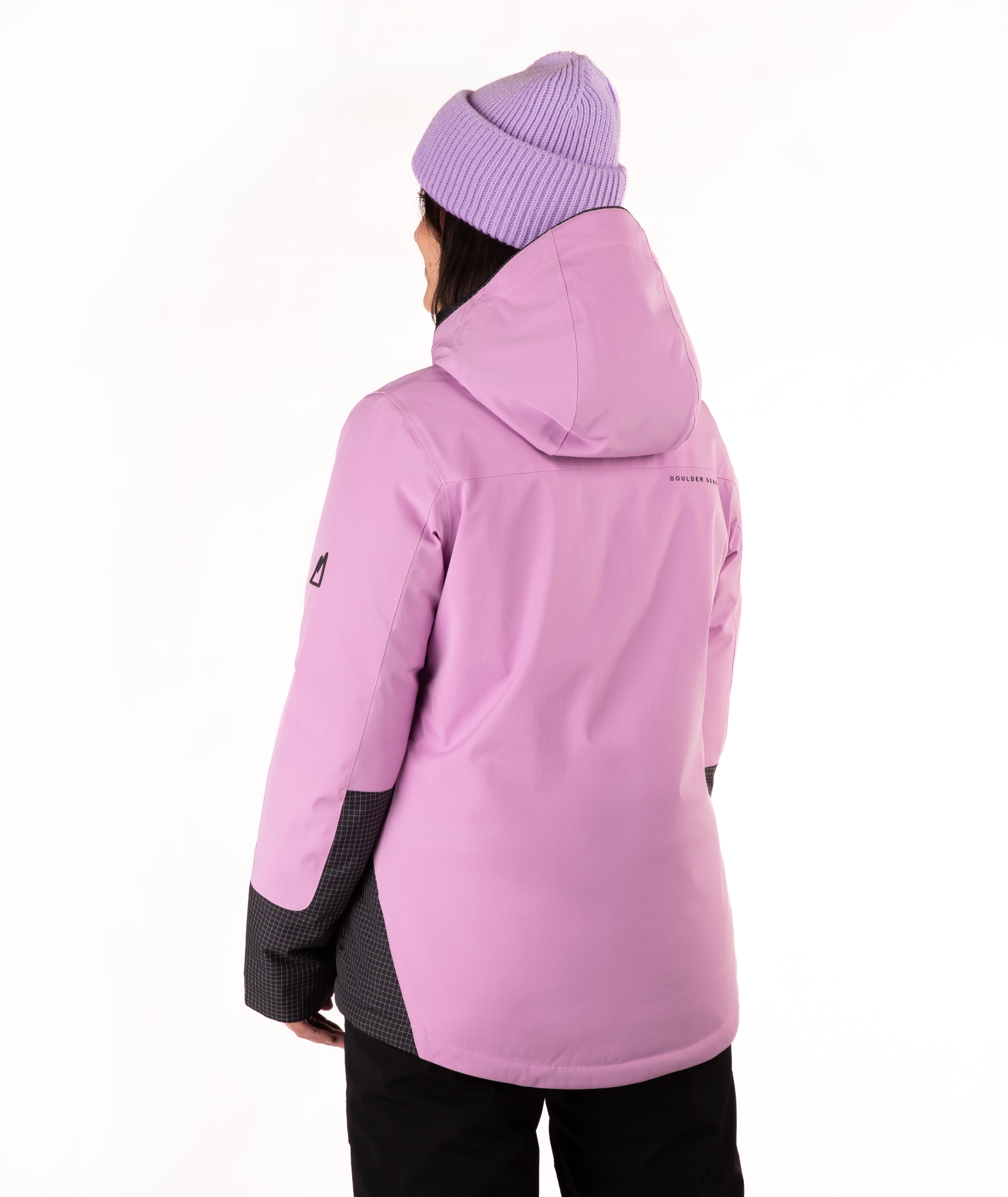 A person shown from the back wearing a light purple ski jacket with black accents on the lower sleeves and sides, paired with a light purple ribbed knit beanie and black pants, against a plain white background.