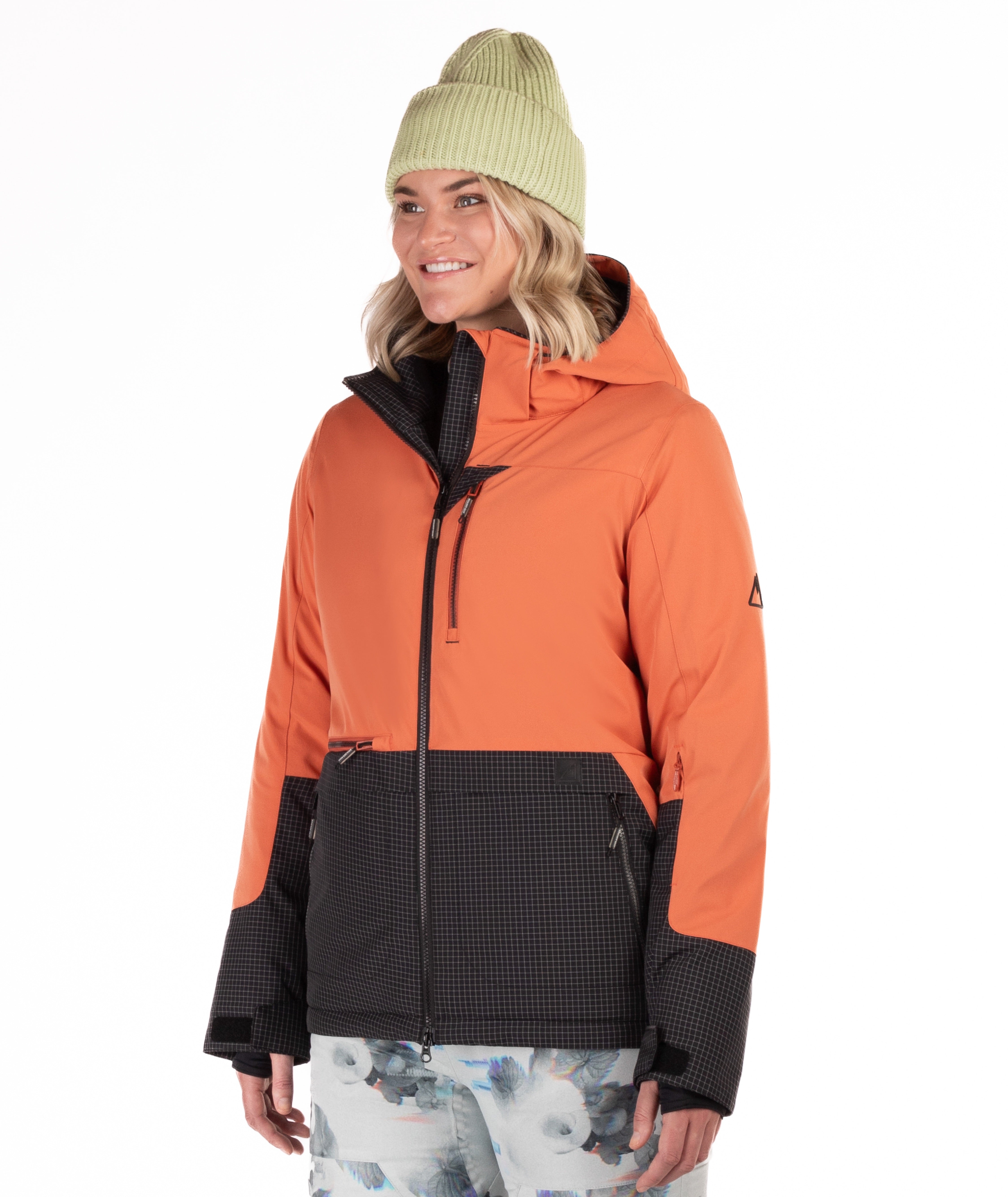 Woman wearing a rust orange and black checkered jacket two tone jacket with a white background