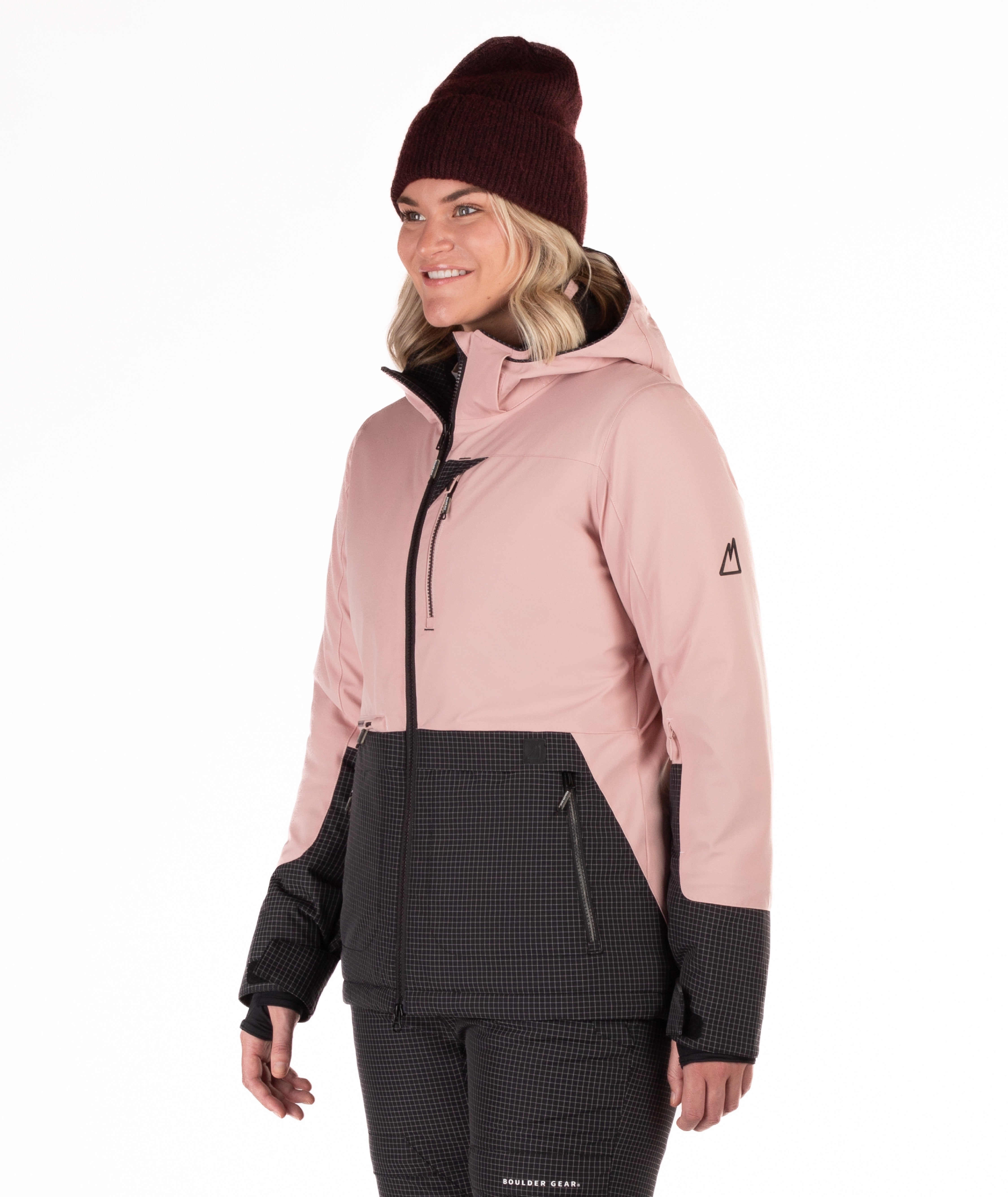 Woman wearing a two-tone pink and black check snow jacket with a white background
