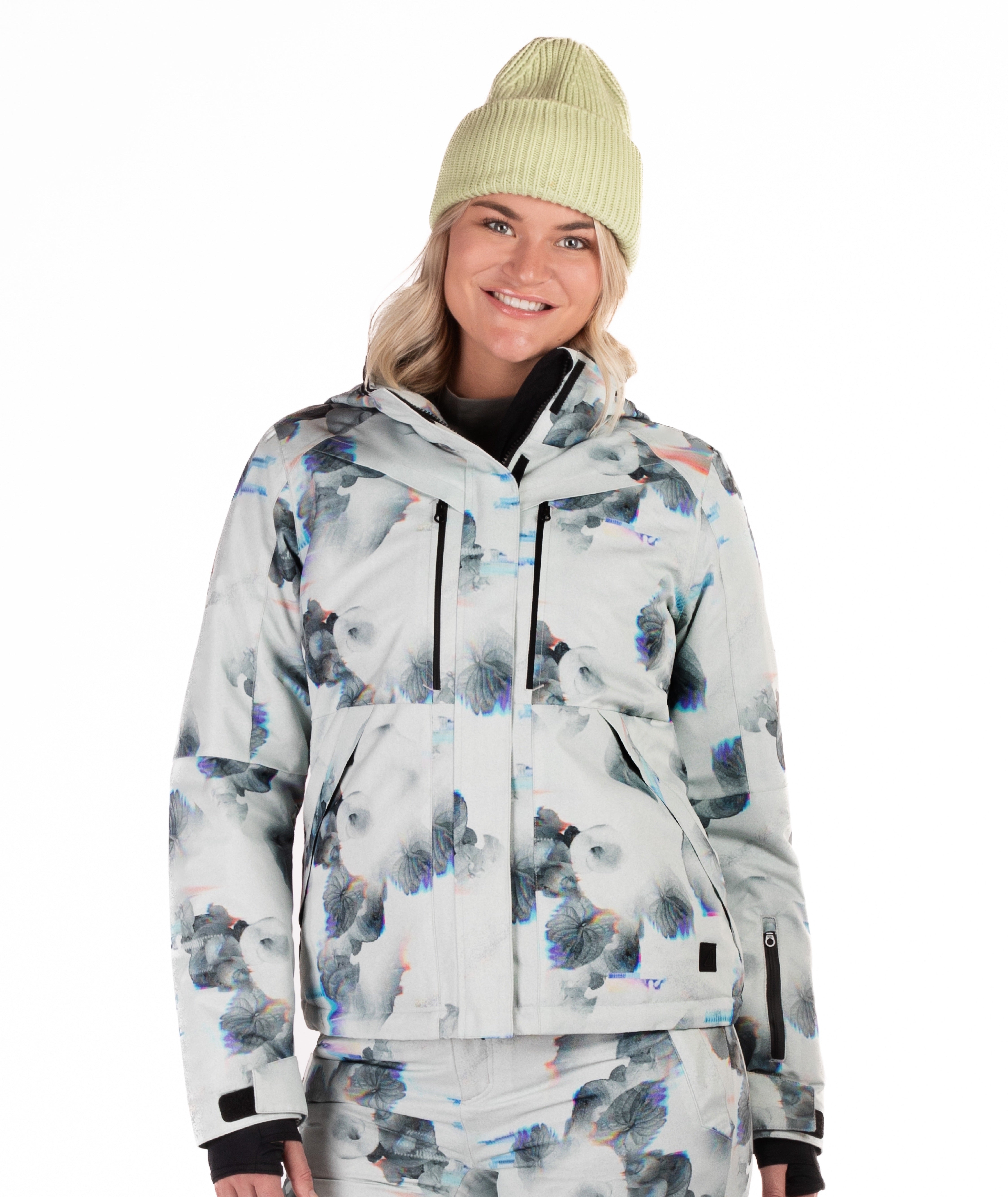 Person wearing a patterned snow jacket with black chest zippers on a white background
