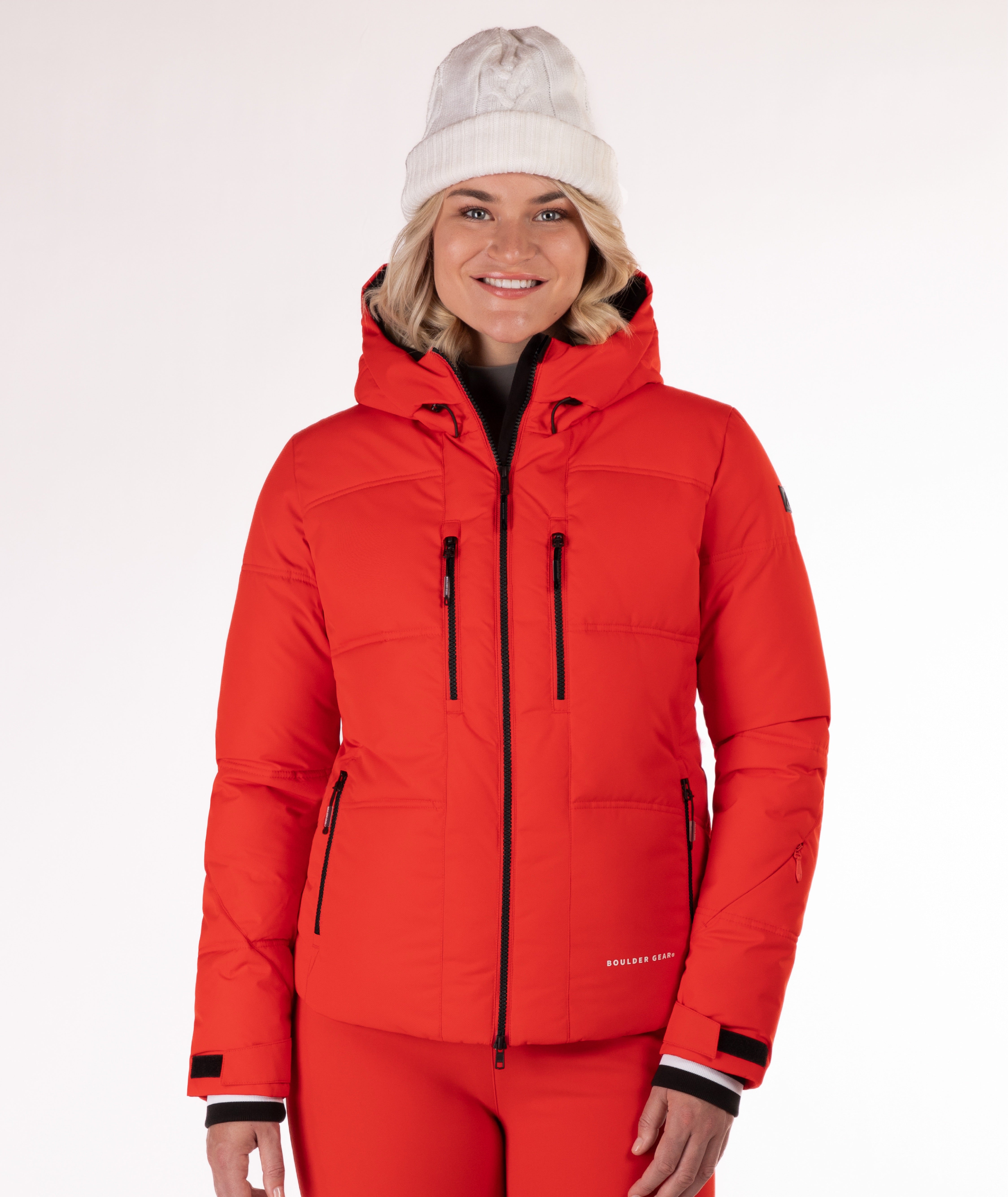 Woman wearing a red quilted winter jacket on a white background