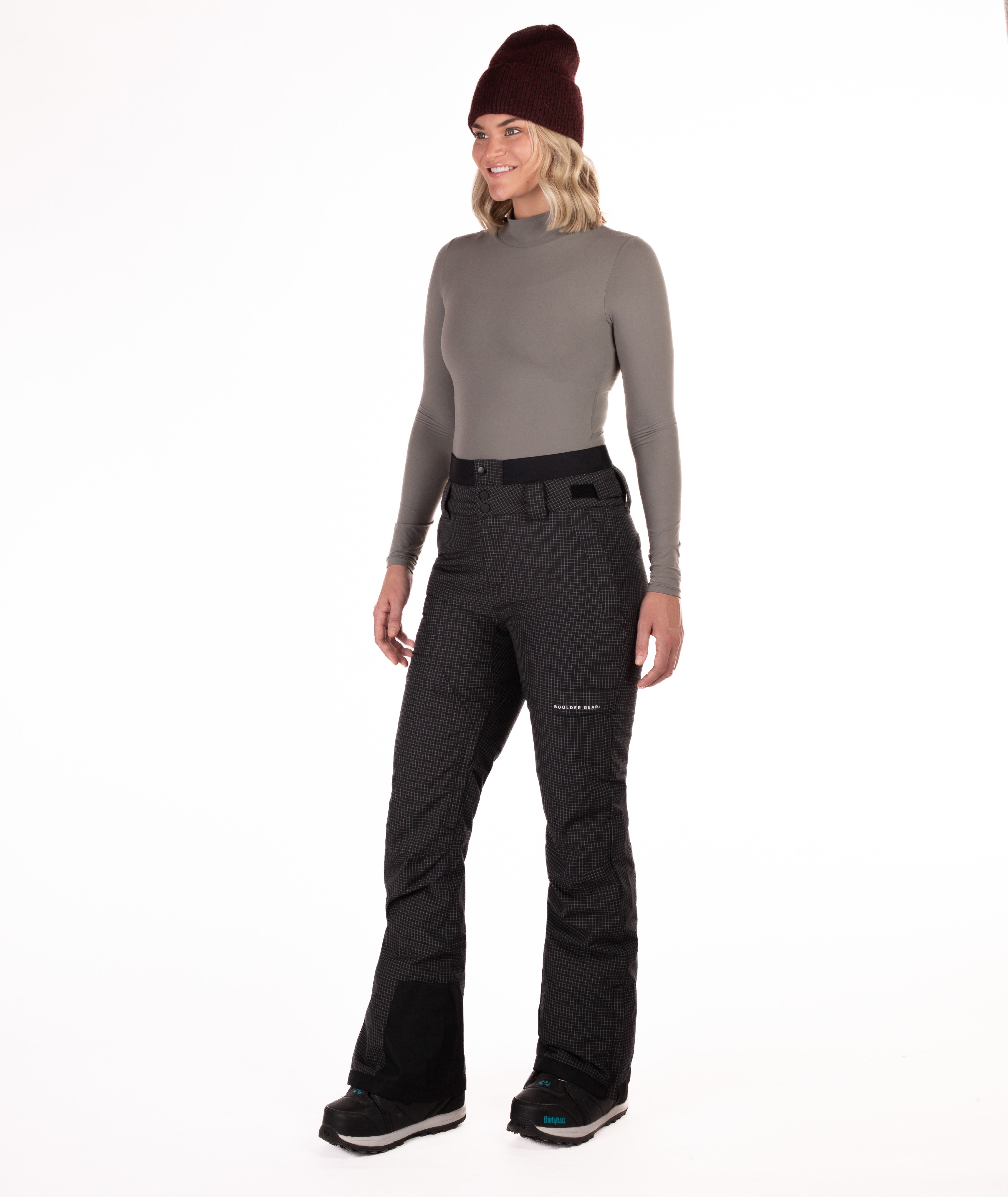 Person wearing black rip stop patterned pants with white thread pants on a white background