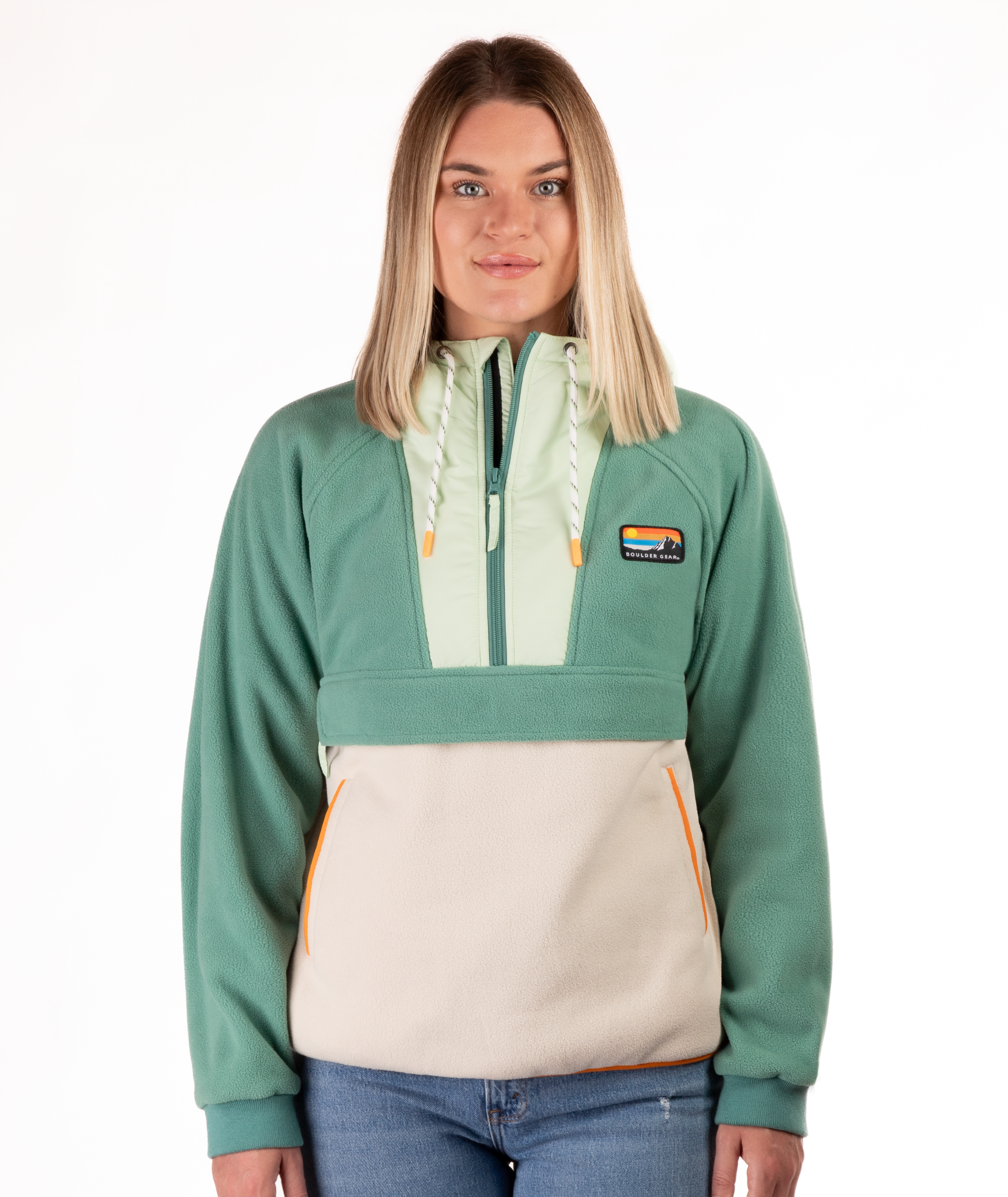Woman wearing a green and beige fleece pullover with a visible brand logo and orange detailing on a white background
