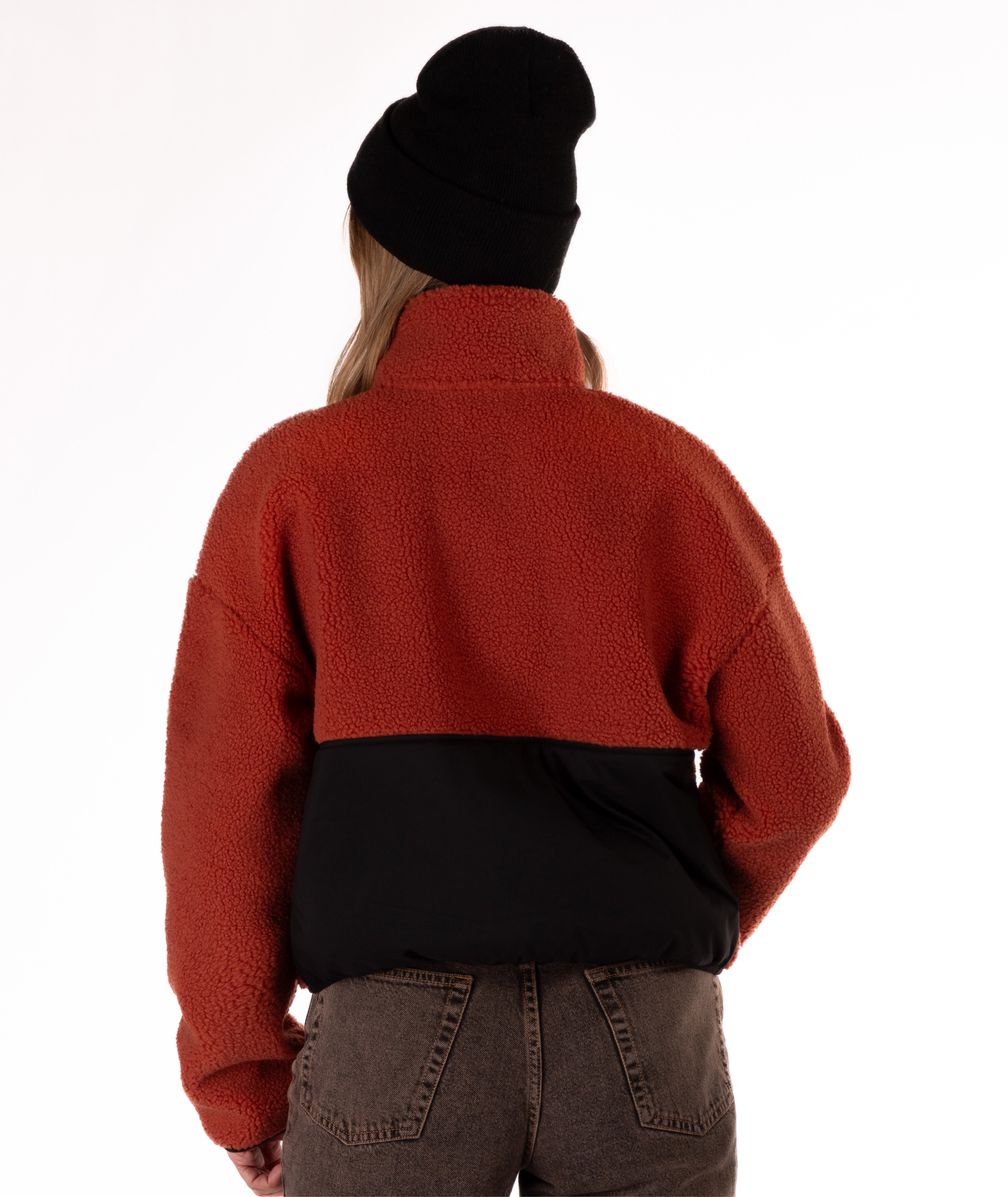 back of Person wearing a red fleece jacket with black zipper on a white background