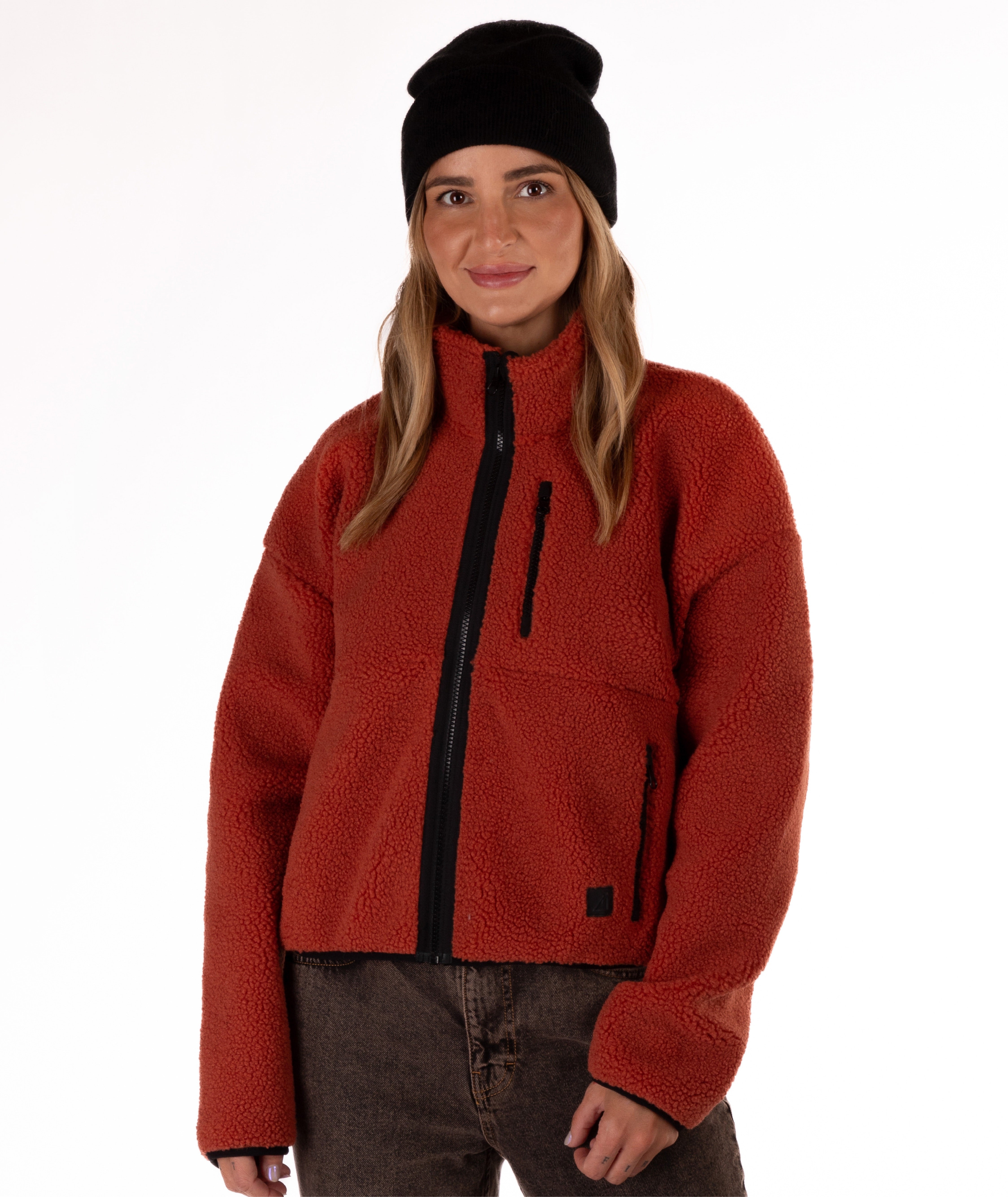 Person wearing a red fleece jacket with black zipper on a white background