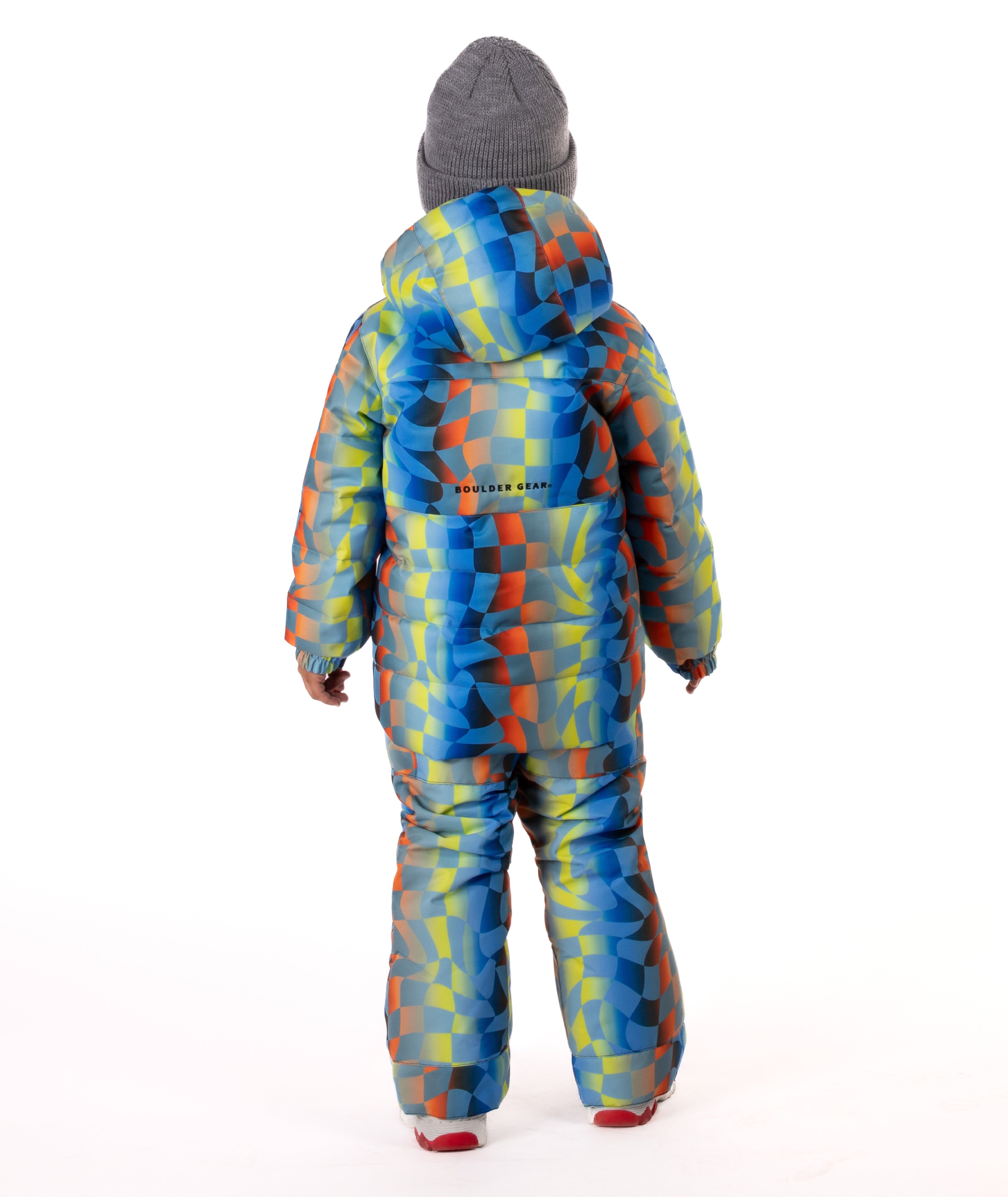 Child wearing a yellow, blue, and orange multi color geometric print quilted winter jacket highlighting a Boulder Gear brand logo