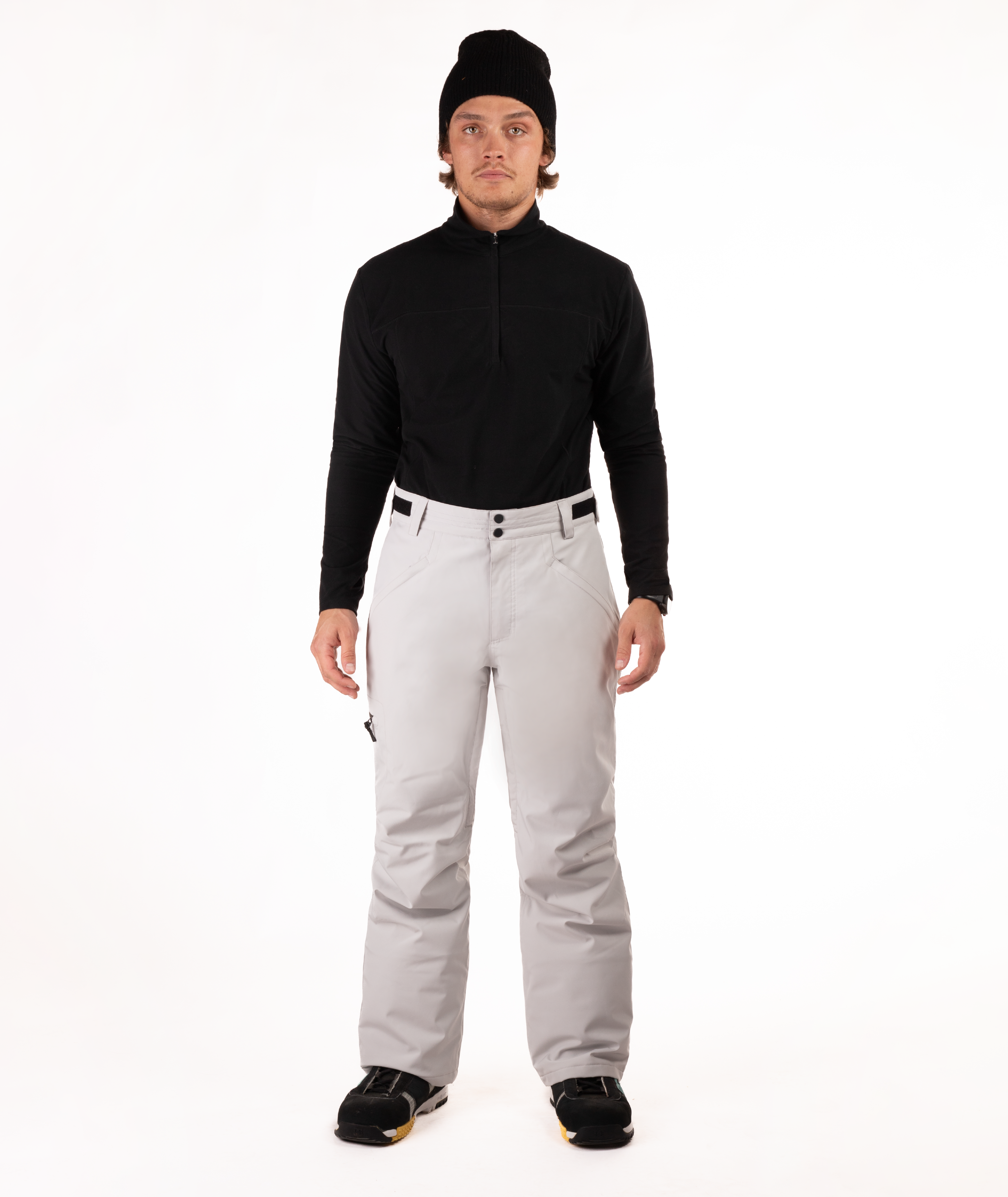 Person wearing a black top and light gray snow pants on a white background