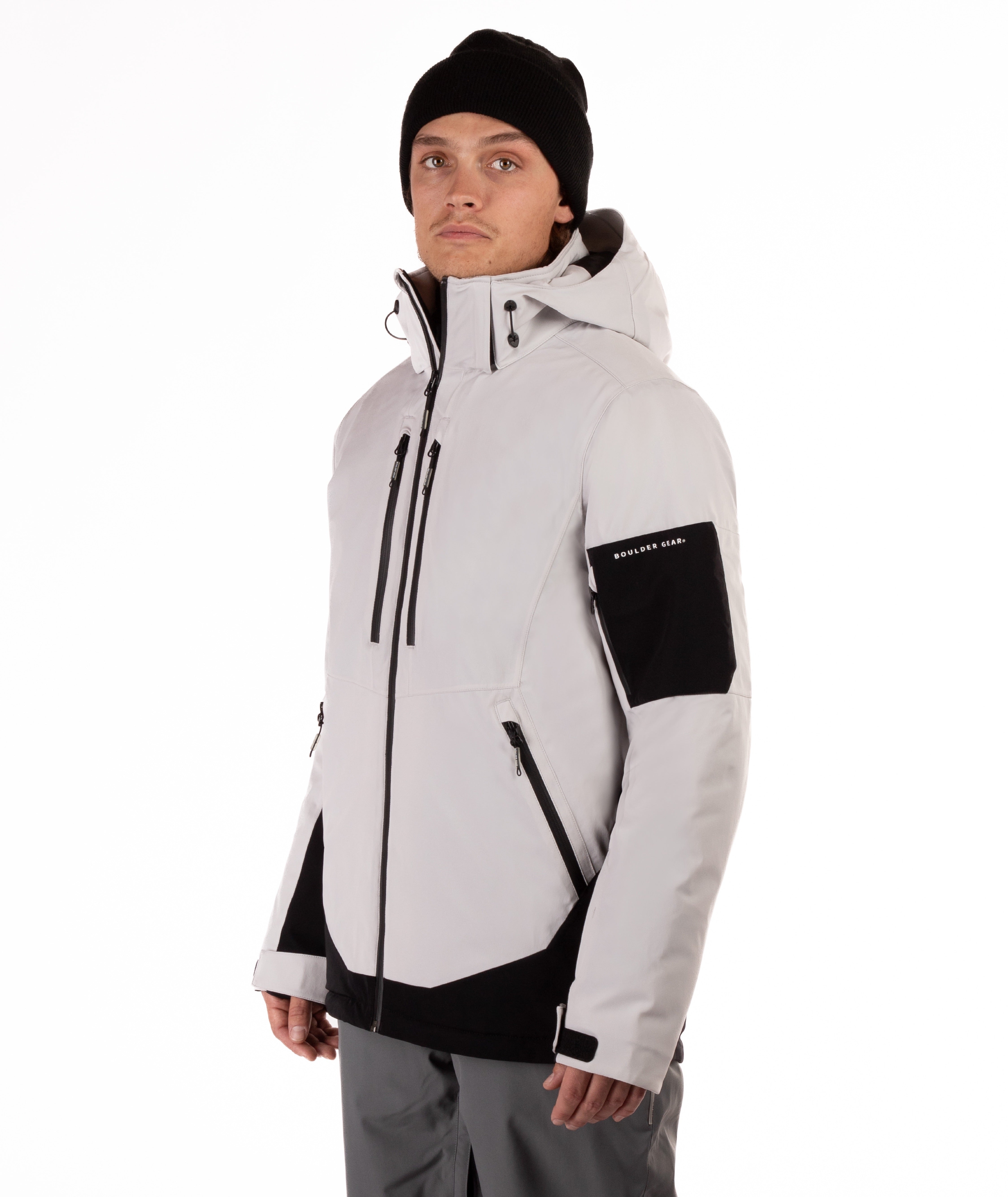 Person wearing a light gray and black jacket with a hood on a white background