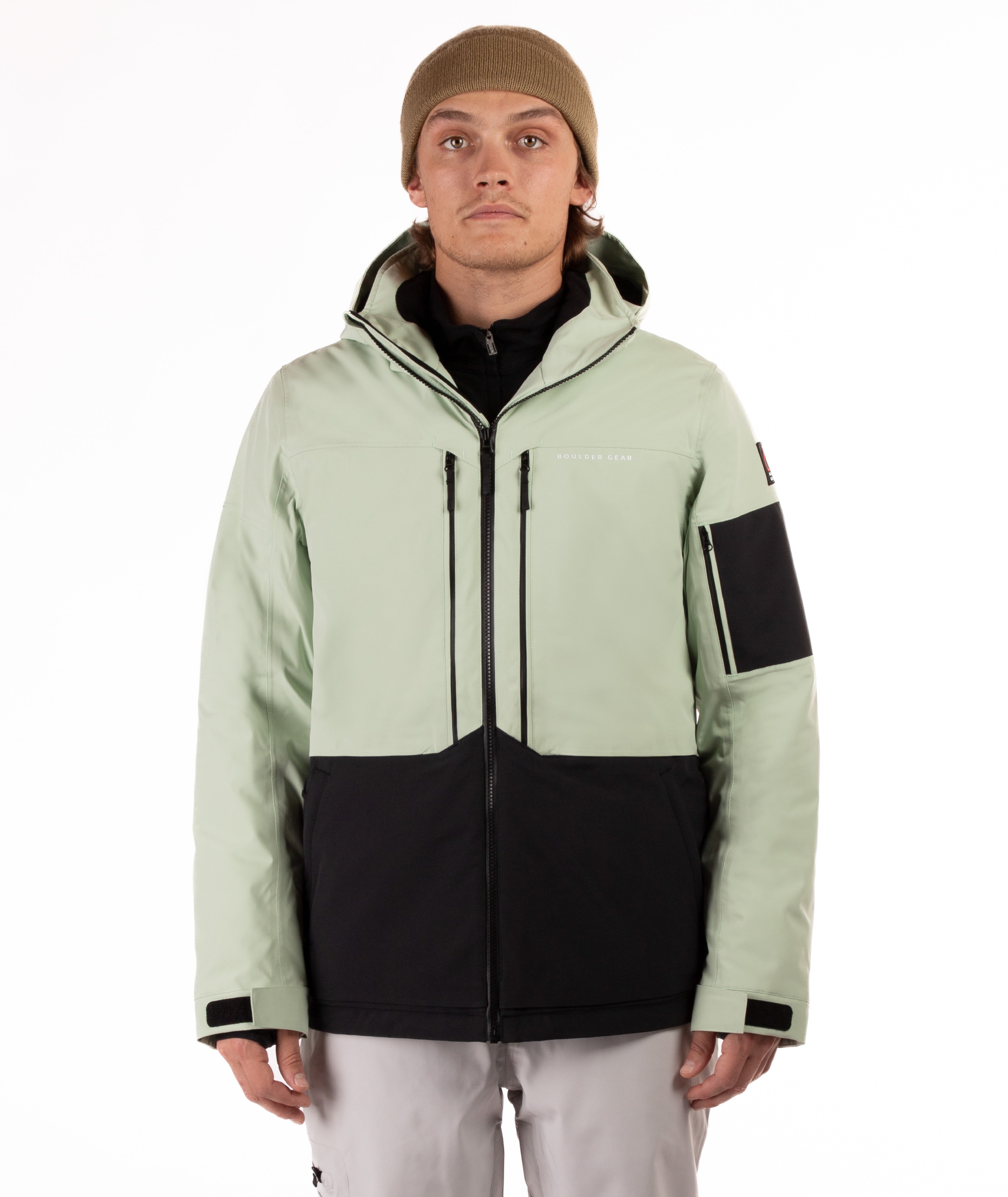 Person wearing a light green and black jacket on a white background