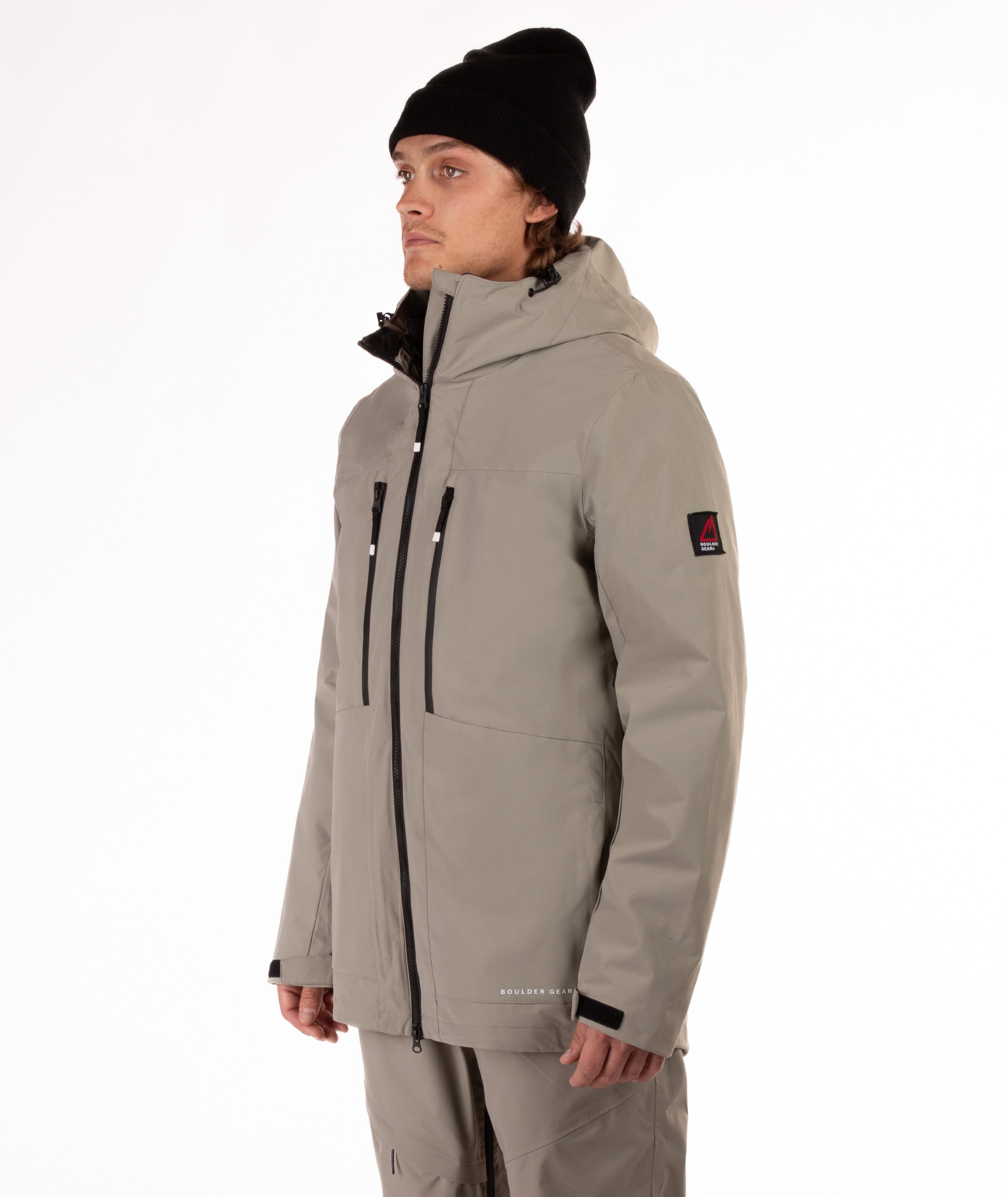 Person wearing a beige jacket with black zippers on a white background