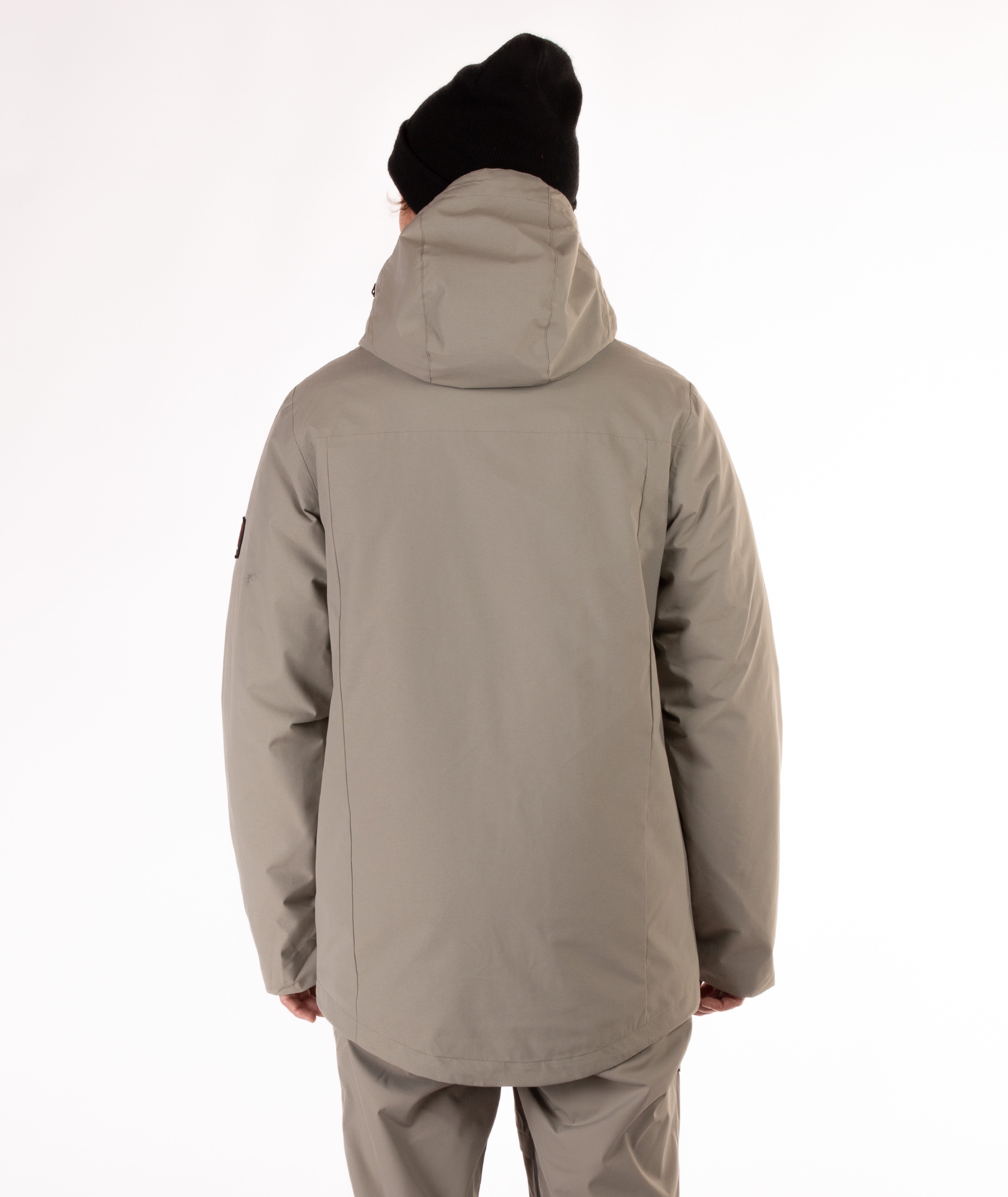 back of a person wearing a beige jacket with black zippers on a white background