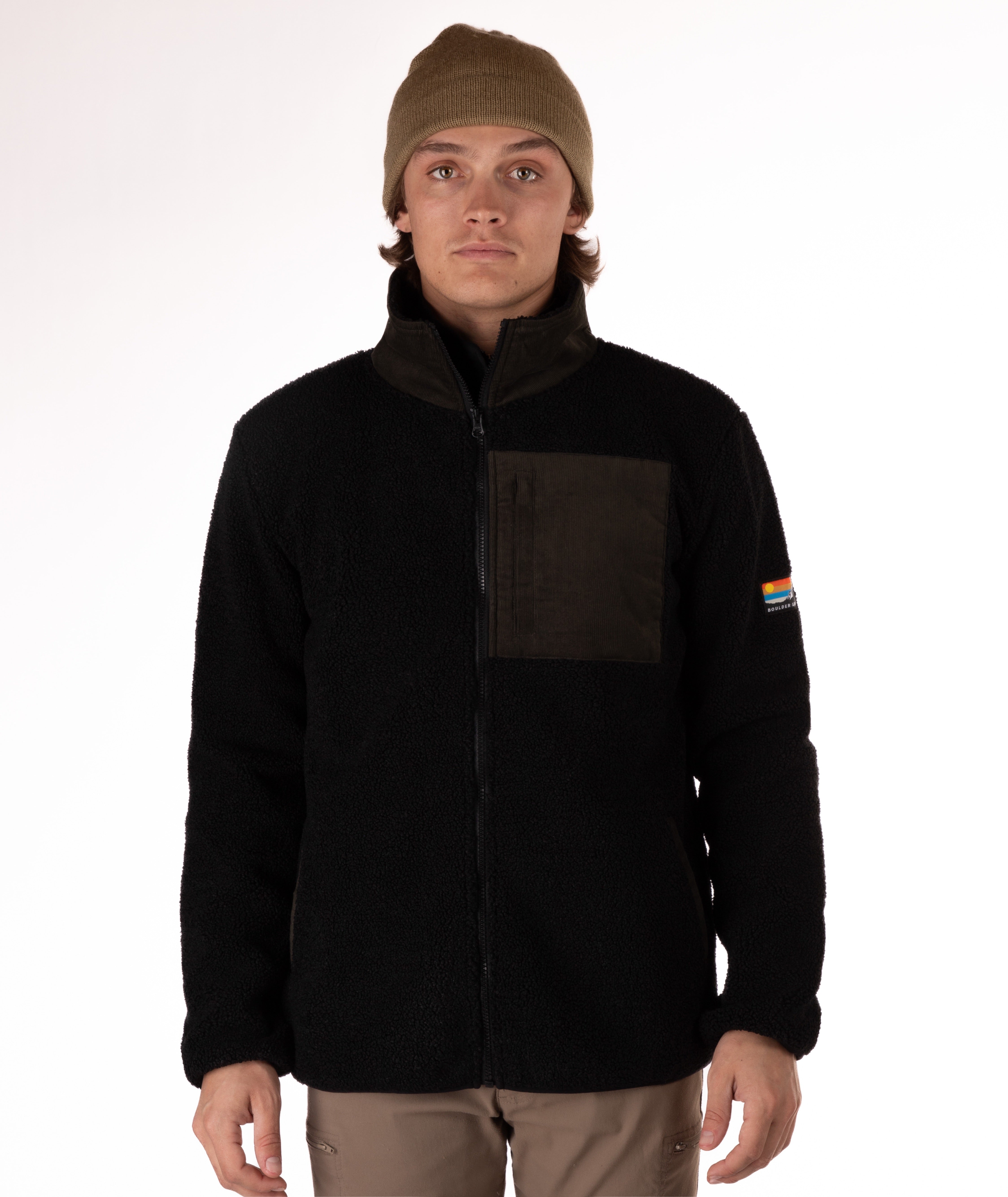 Man wearing a black fleece jacket with a green chest pocket and collar on a white background