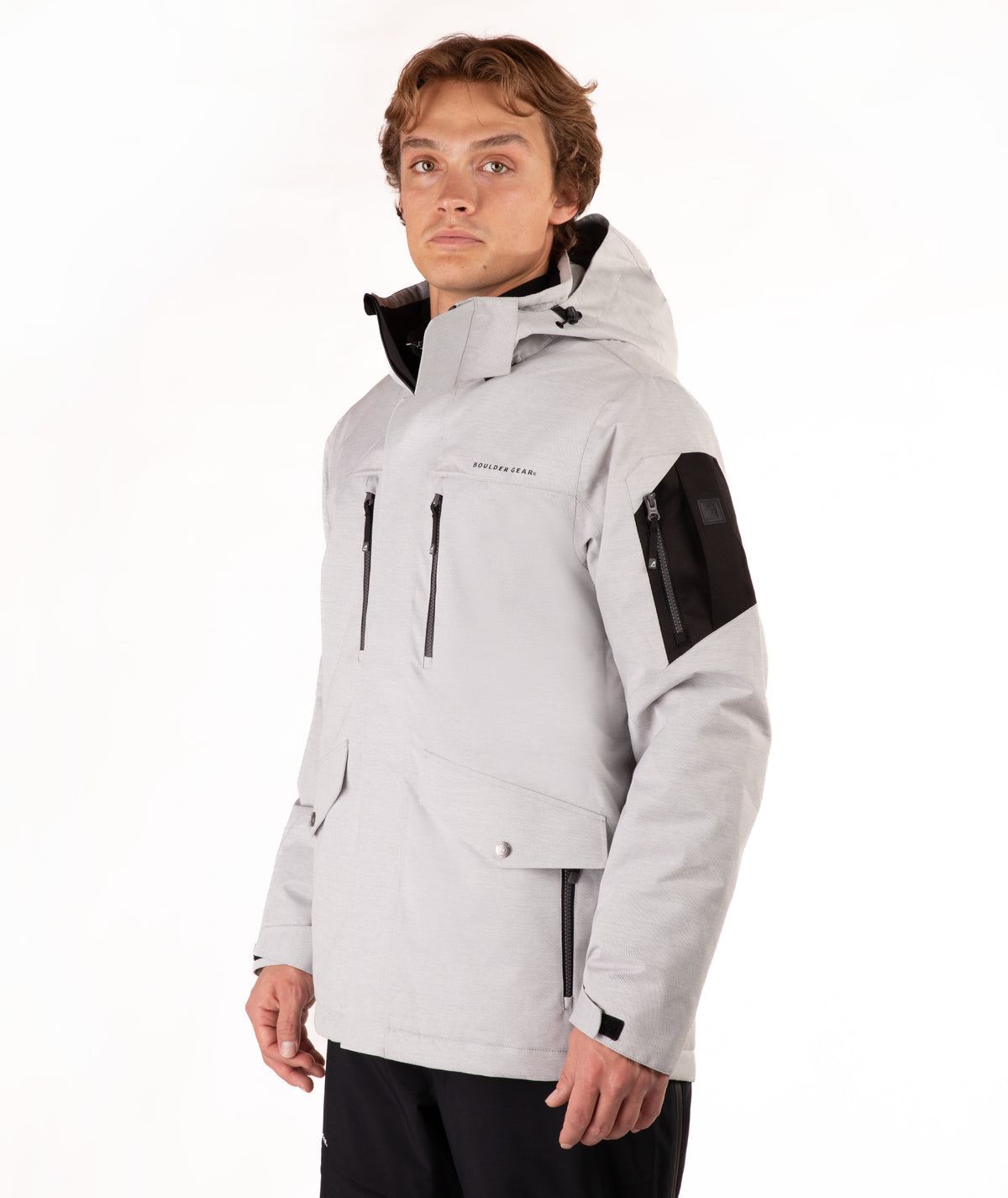A man wearing a light gray hooded ski jacket with black accents on the chest, sleeves, and hood, posed against a solid white studio background.