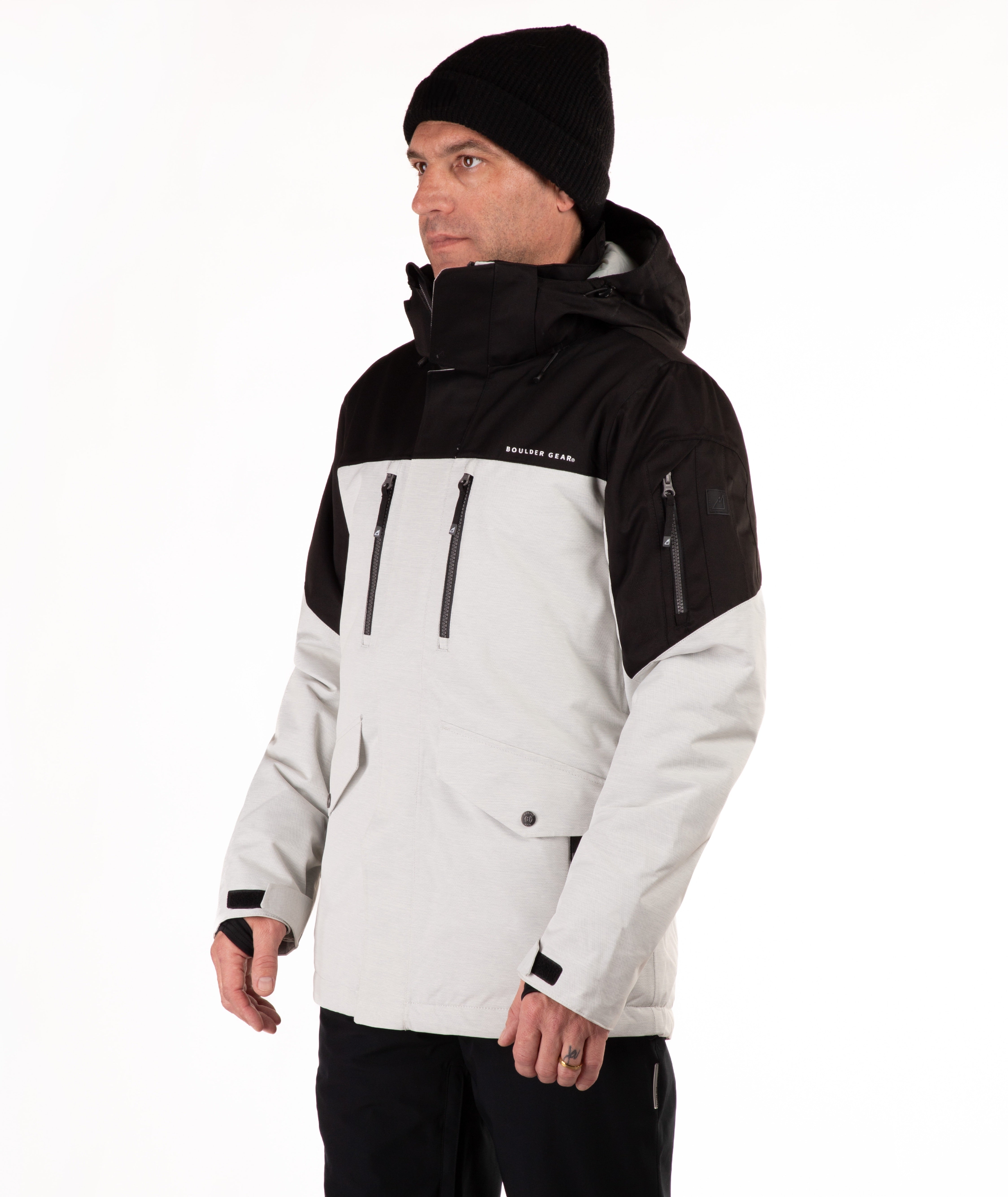 Man wearing a black and light gray jacket with a visible brand logo on a white background