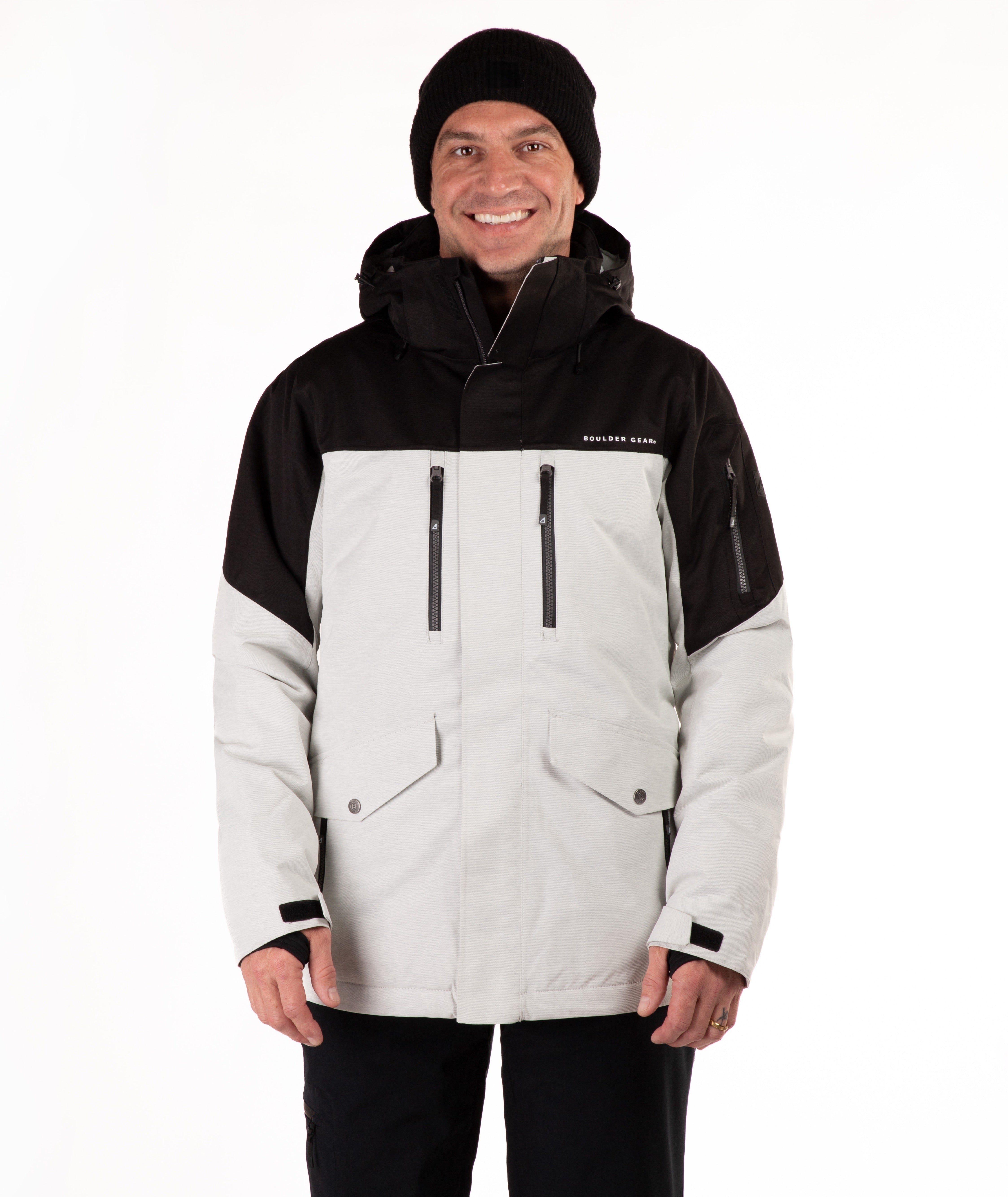 Man wearing a black and light gray jacket with a visible brand logo on a white background