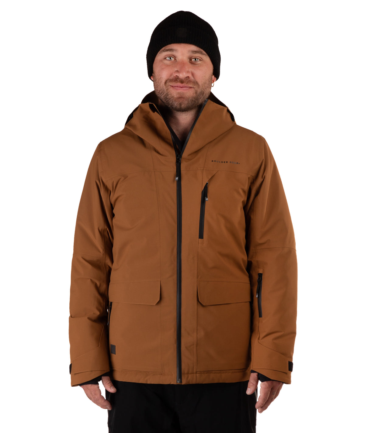 A man wearing a brown hooded technical jacket with black zippers, a black beanie, and black pants, photographed against a plain white studio background.