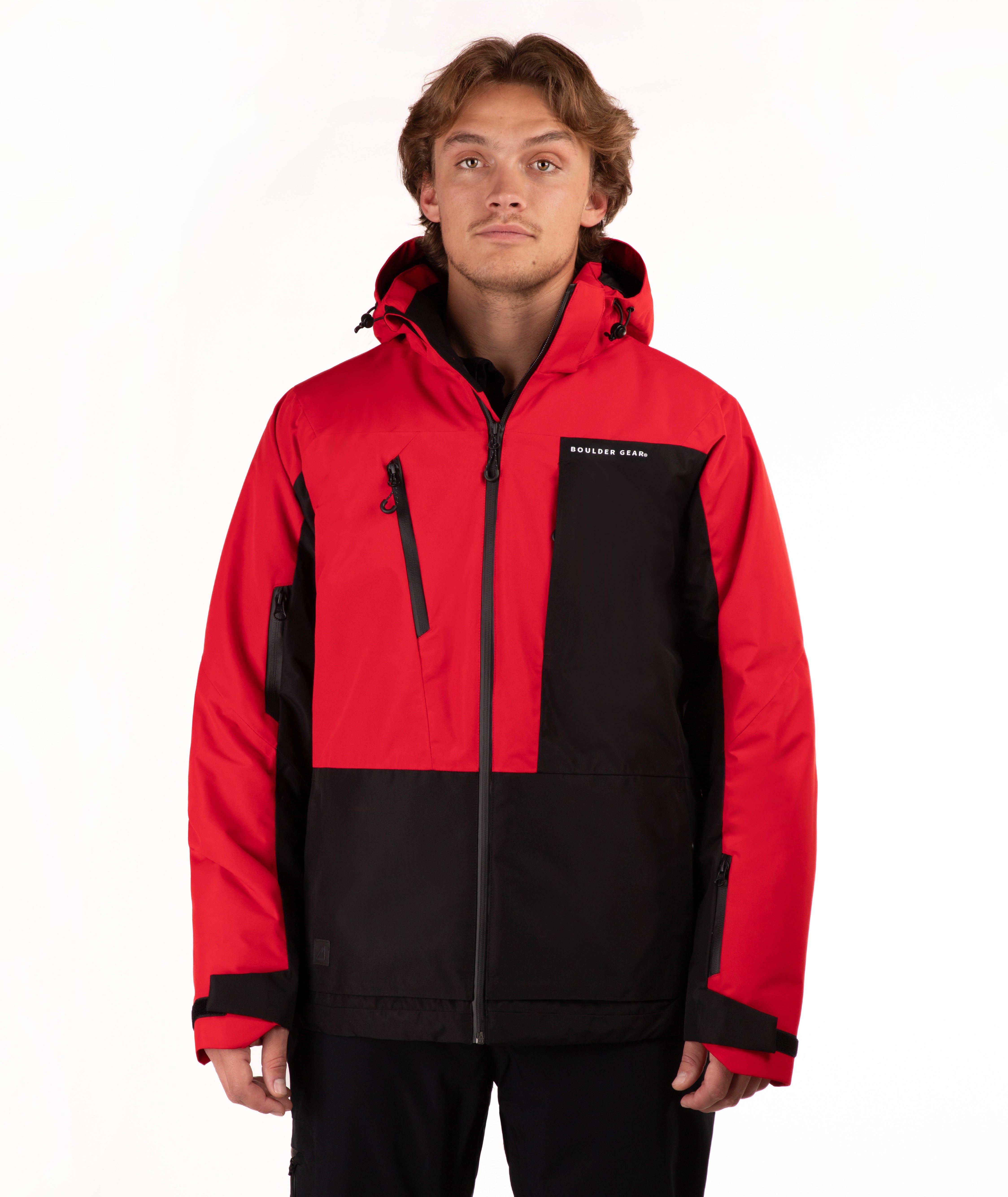 A man wearing a red and black color-blocked ski jacket with a full-zip front and hood, standing against a plain white studio background.