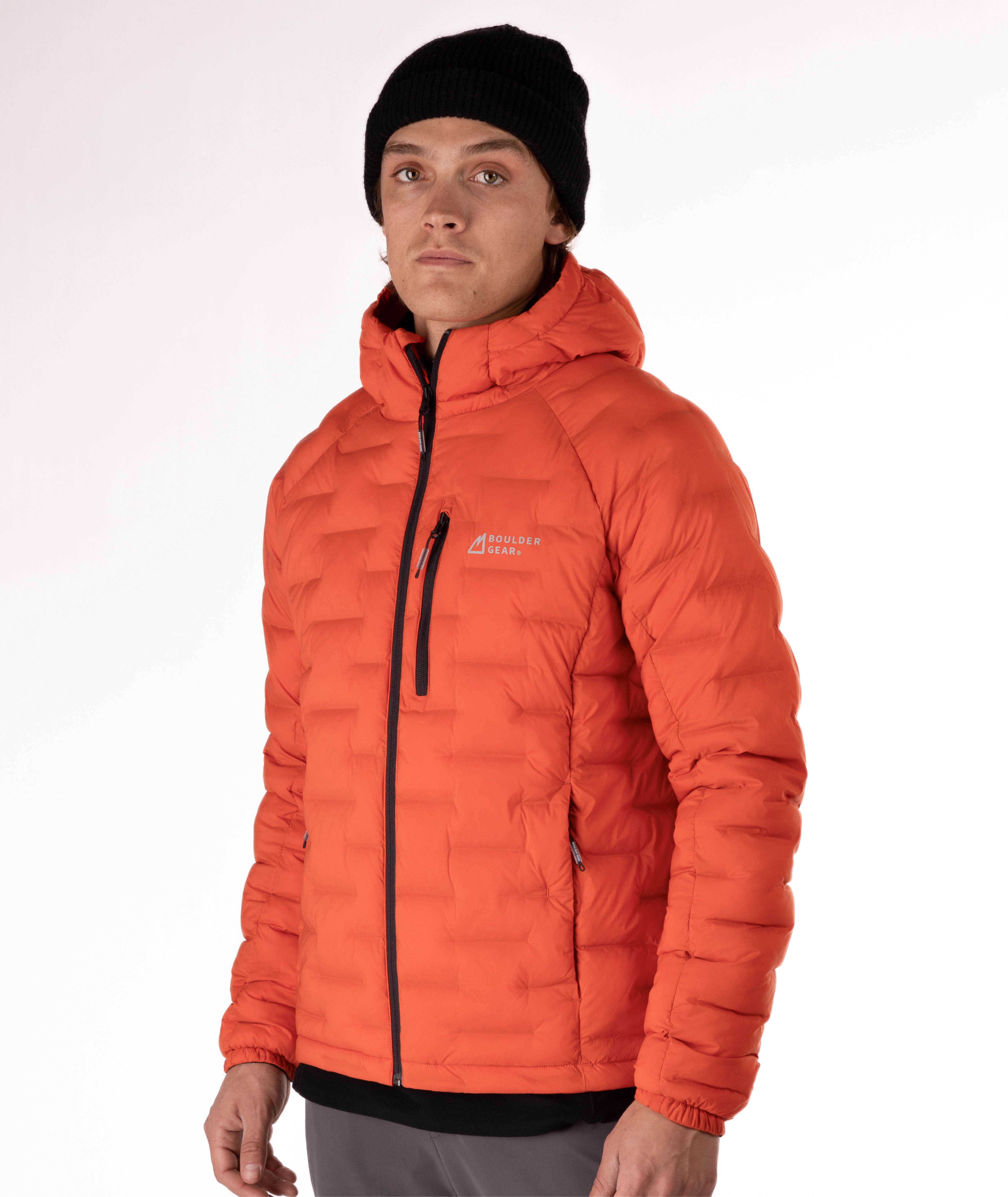 Man wearing a orange puffer jacket with black zippers and a brand logo on a white background