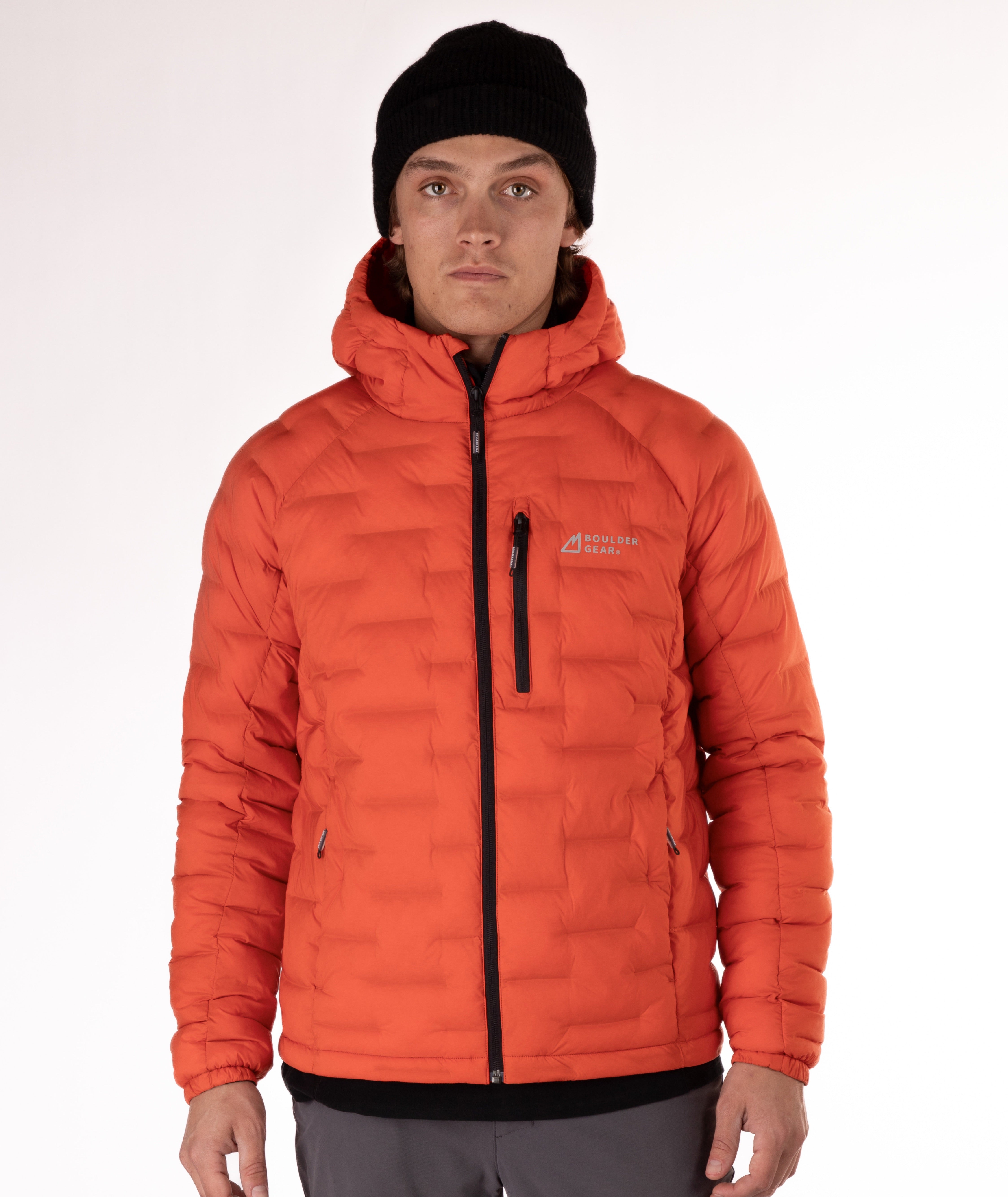 Man wearing a orange puffer jacket with black zippers and a brand logo on a white background