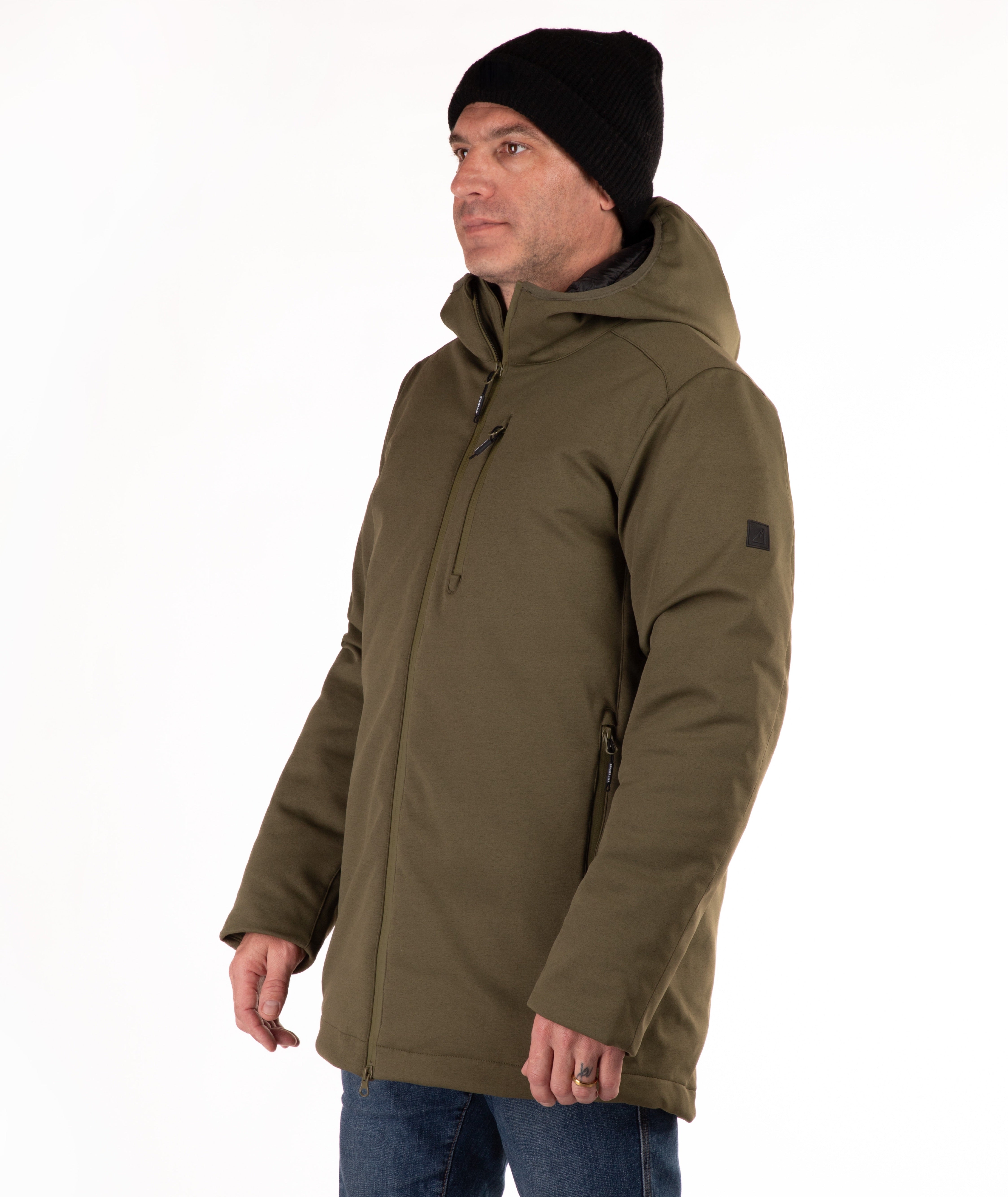 Man wearing a green hooded jacket and black beanie on a white