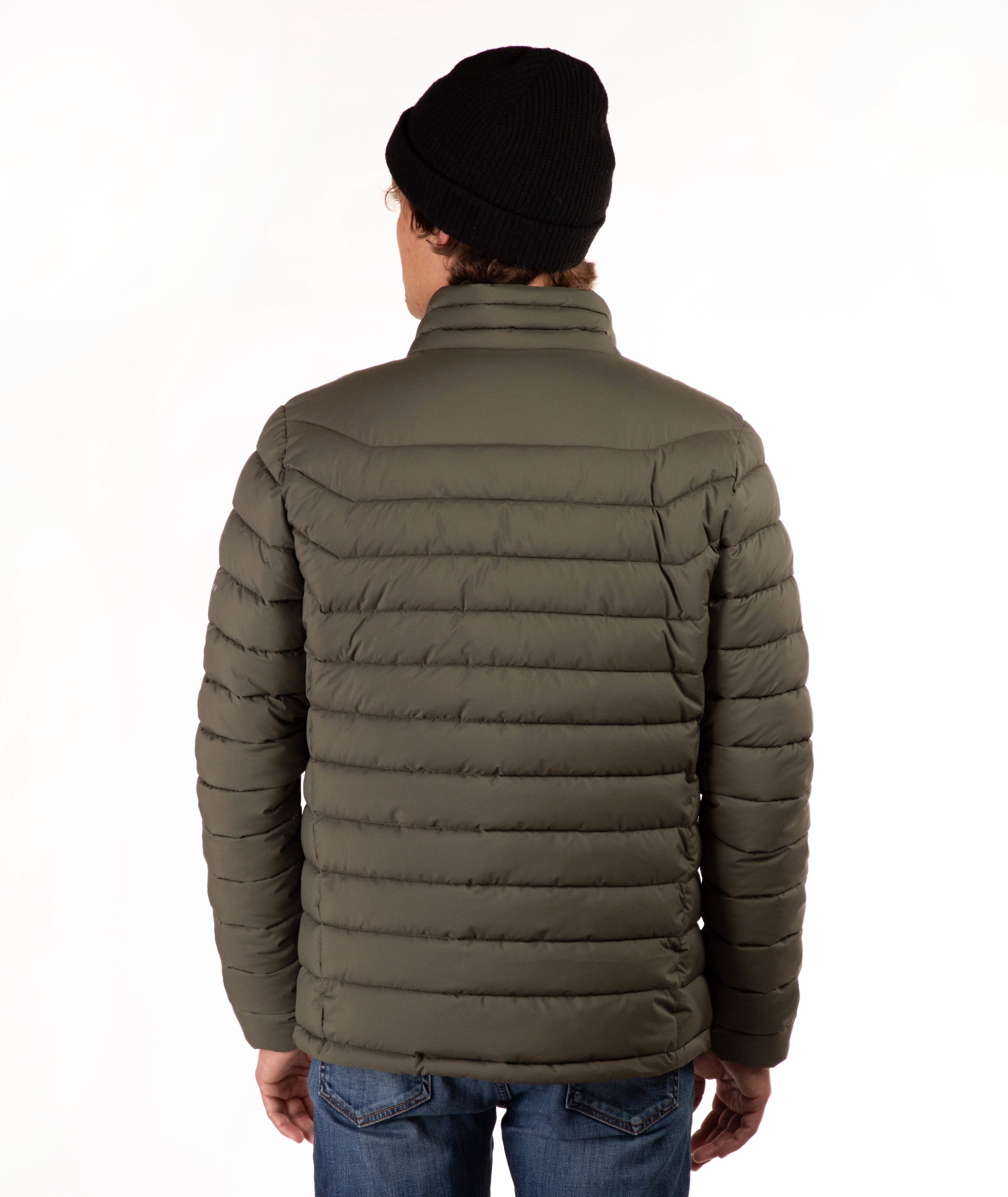 A man viewed from the back wearing an olive green puffer jacket, a black knit beanie, and blue jeans against a plain white background.