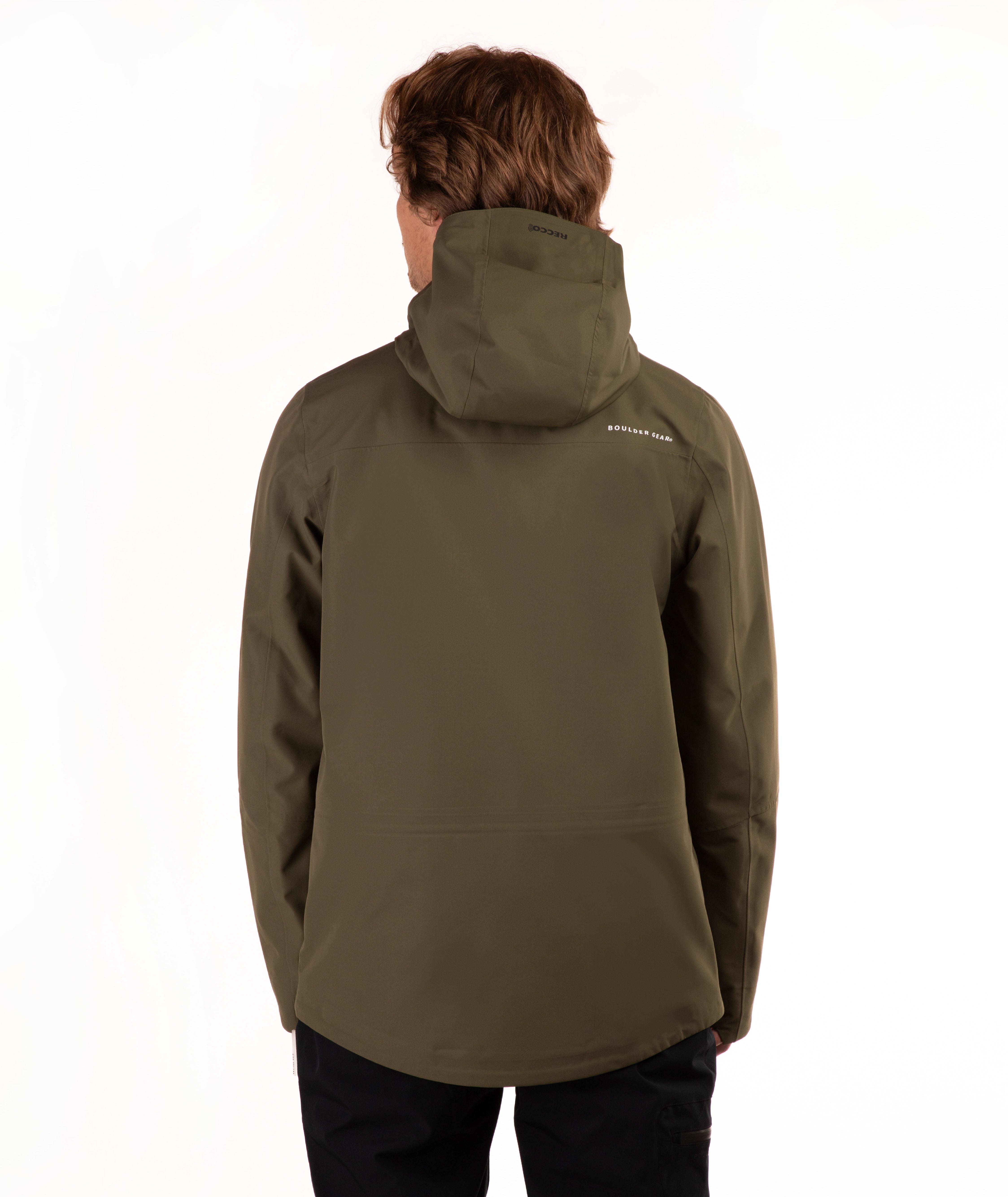 A man viewed from the back wearing an olive green hooded jacket and black pants against a plain white background.