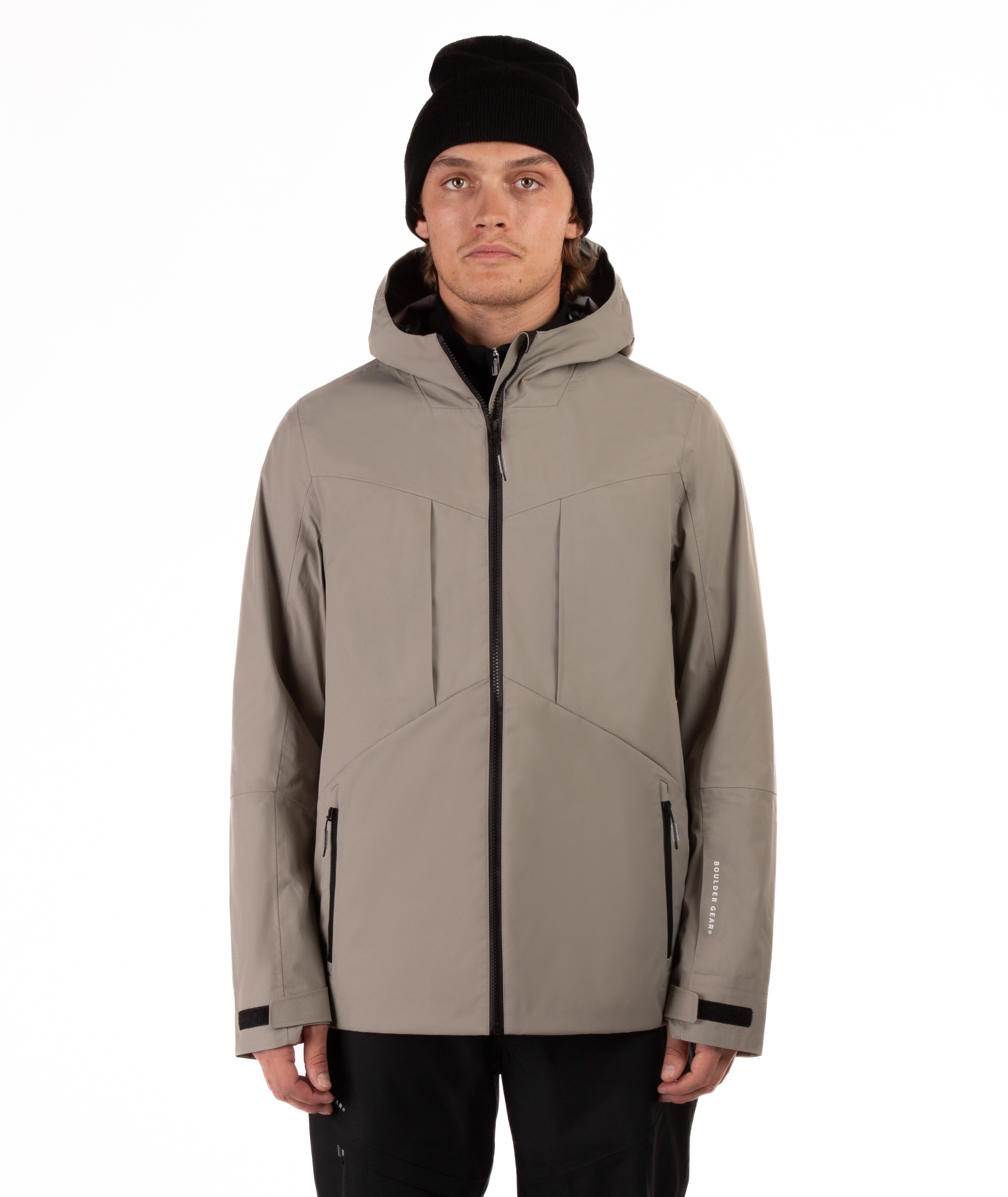 Man wearing a beige jacket with black accents on a white background