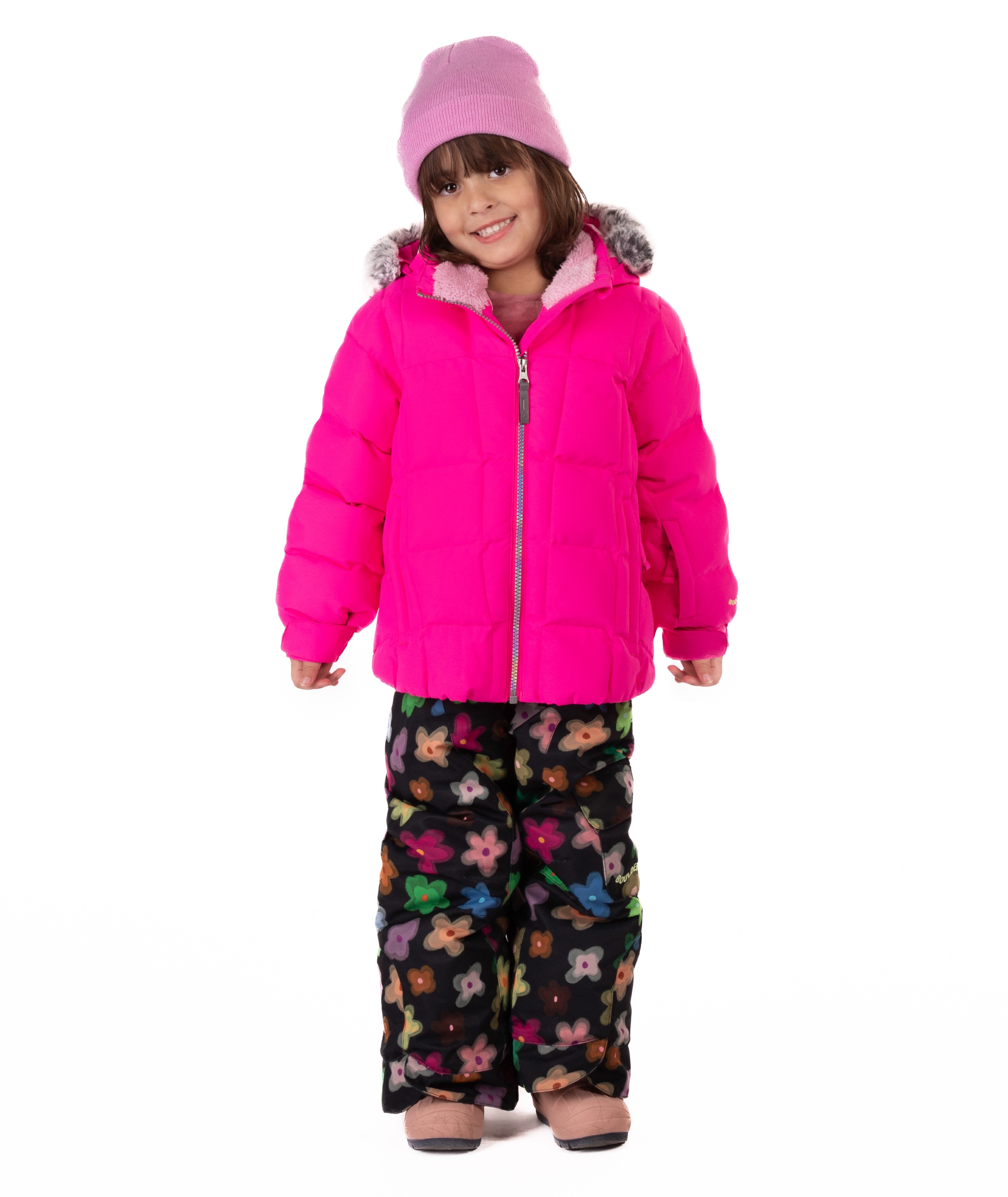 Child wearing a bright pink quilted puffy winter coat on a white background