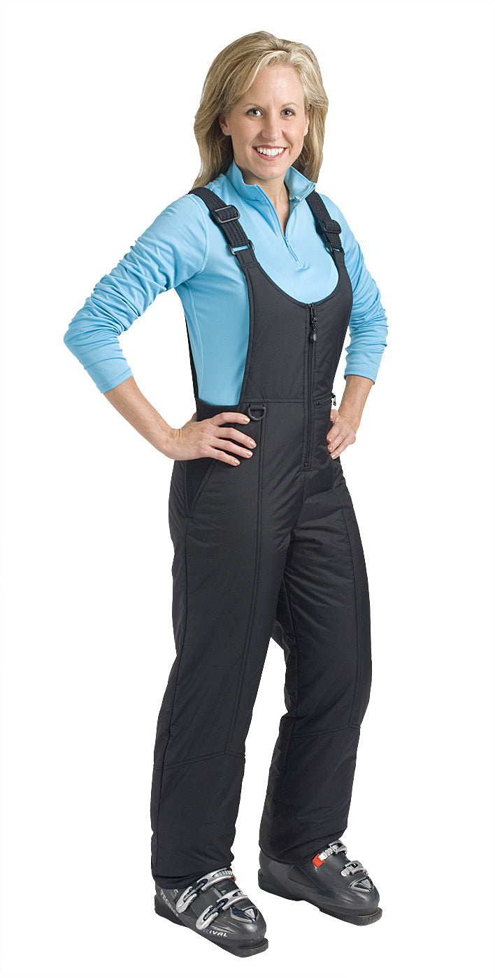 A woman wearing a black snow bib with adjustable shoulder straps on a white background
