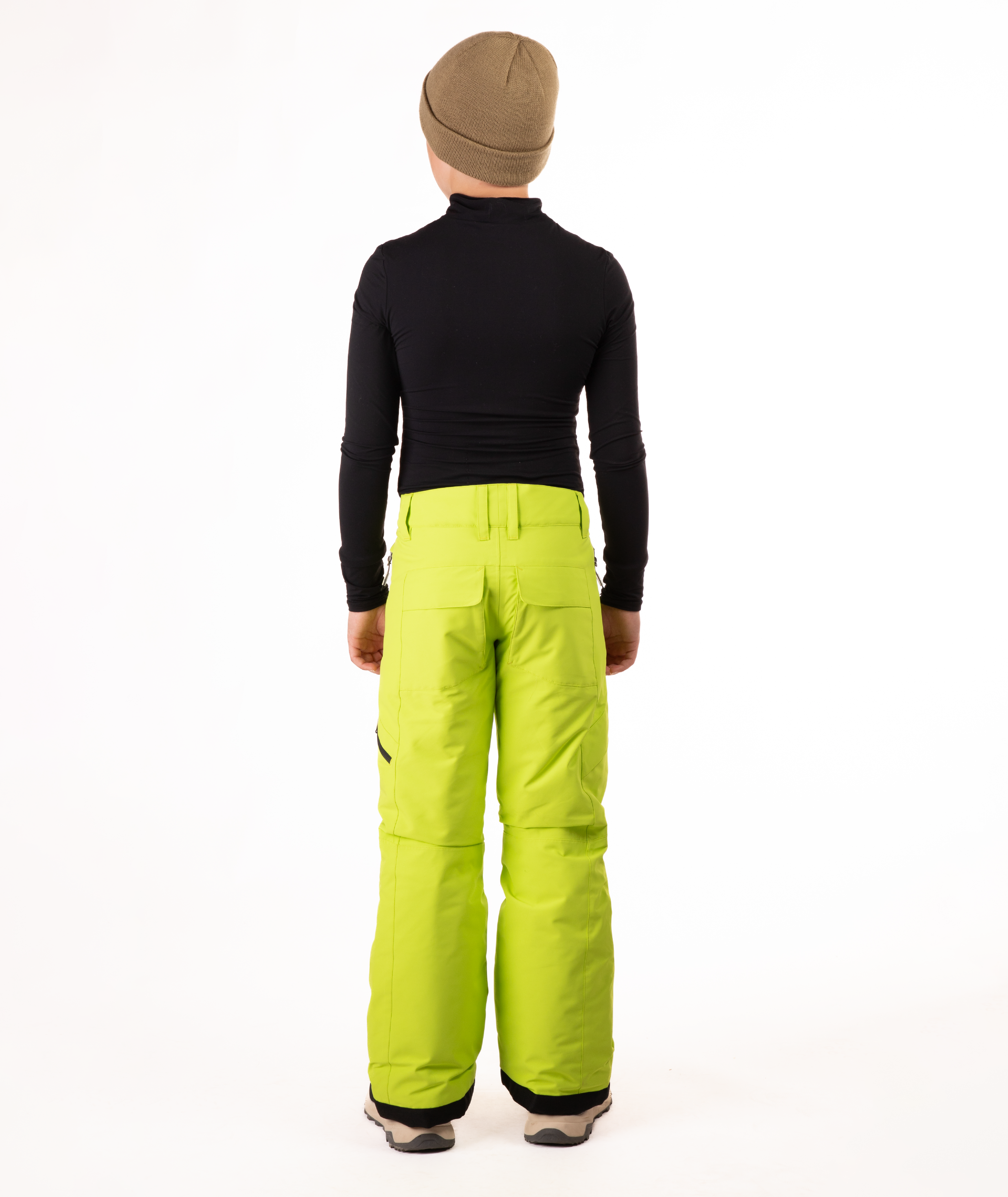 back of youth boy wearing a black long-sleeve shirt and bright green snow pants on a white background