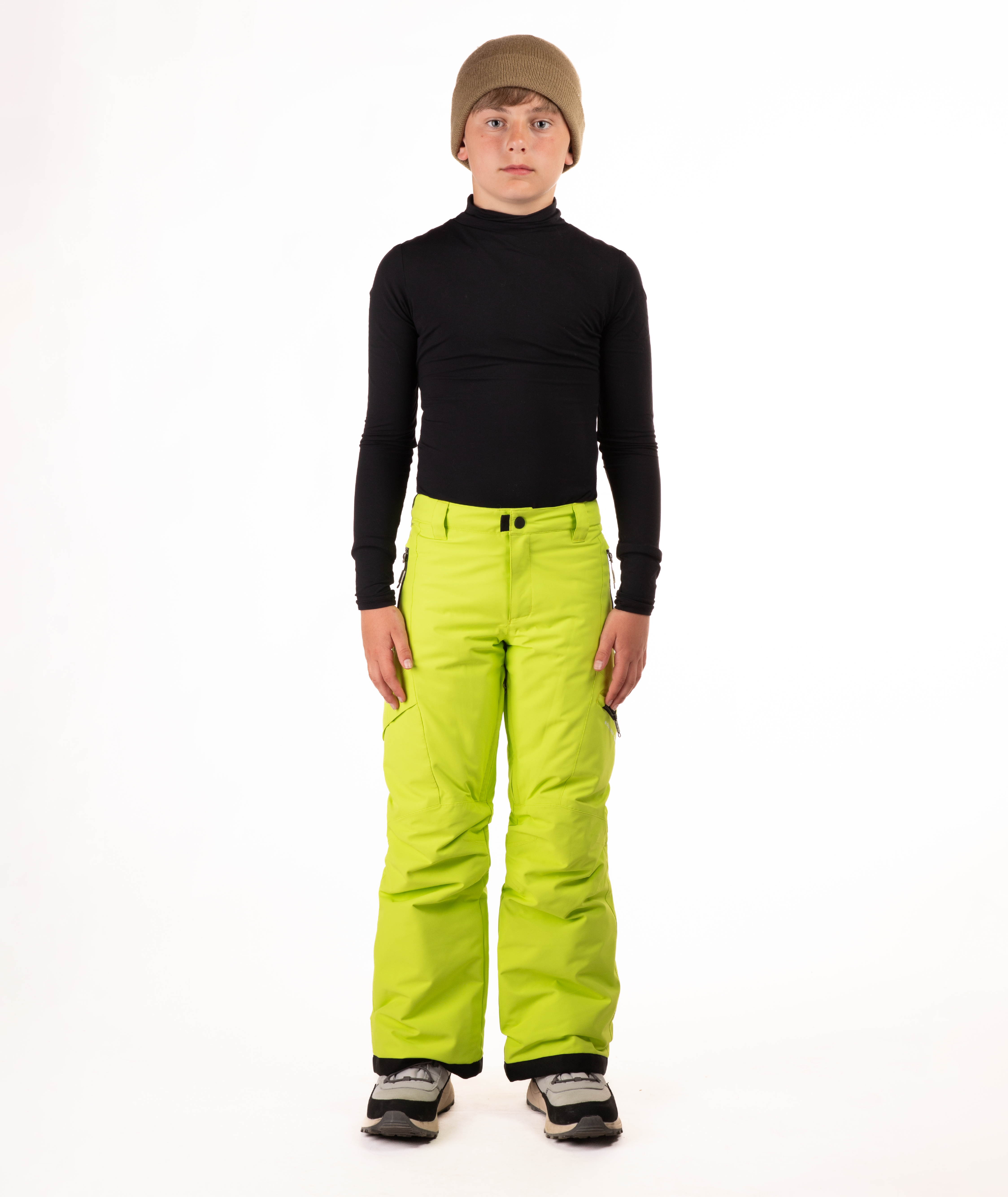 youth boy wearing a black long-sleeve shirt and bright green snow pants on a white background