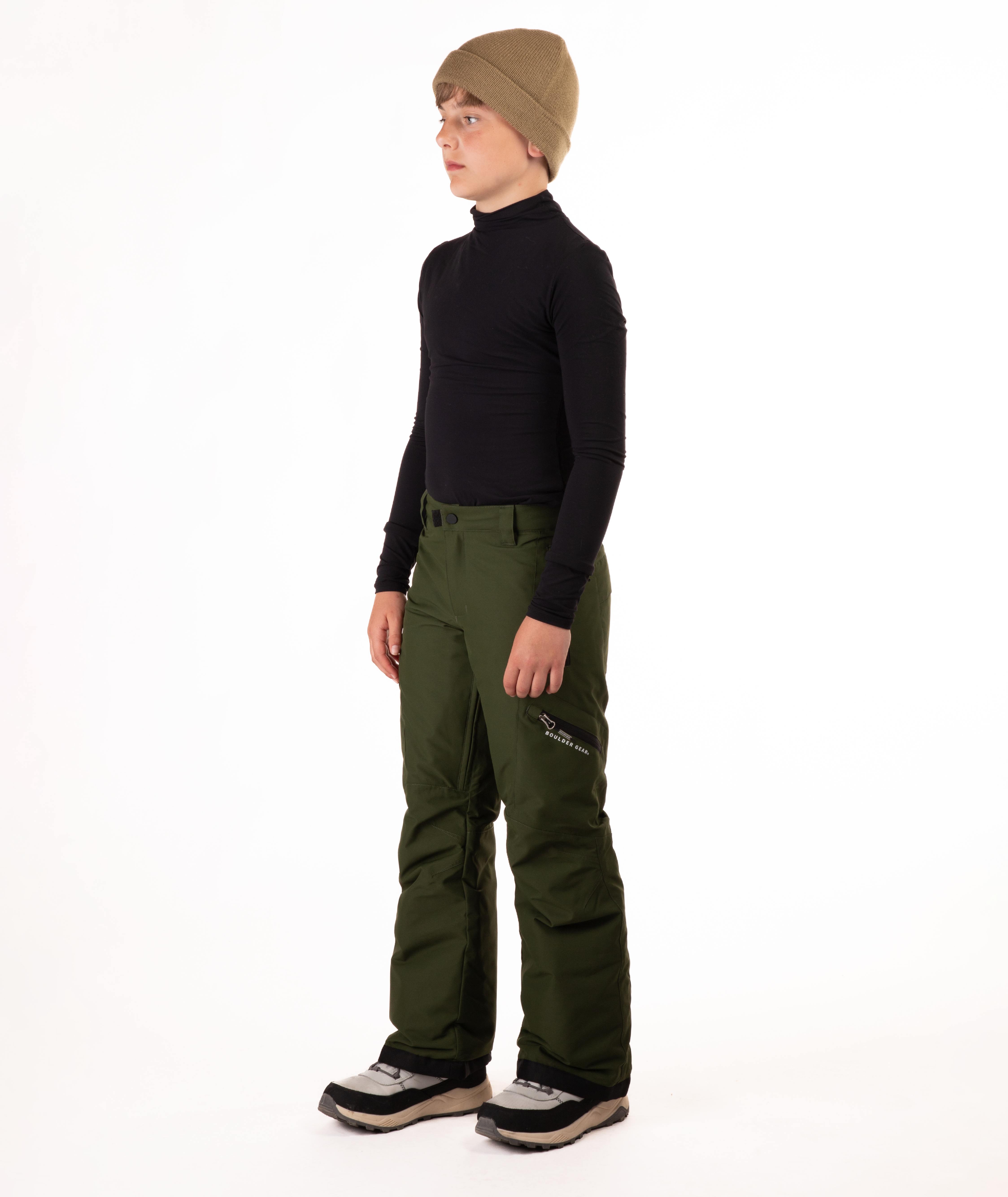 youth boy wearing a black long-sleeve shirt and green snow pants on a white background