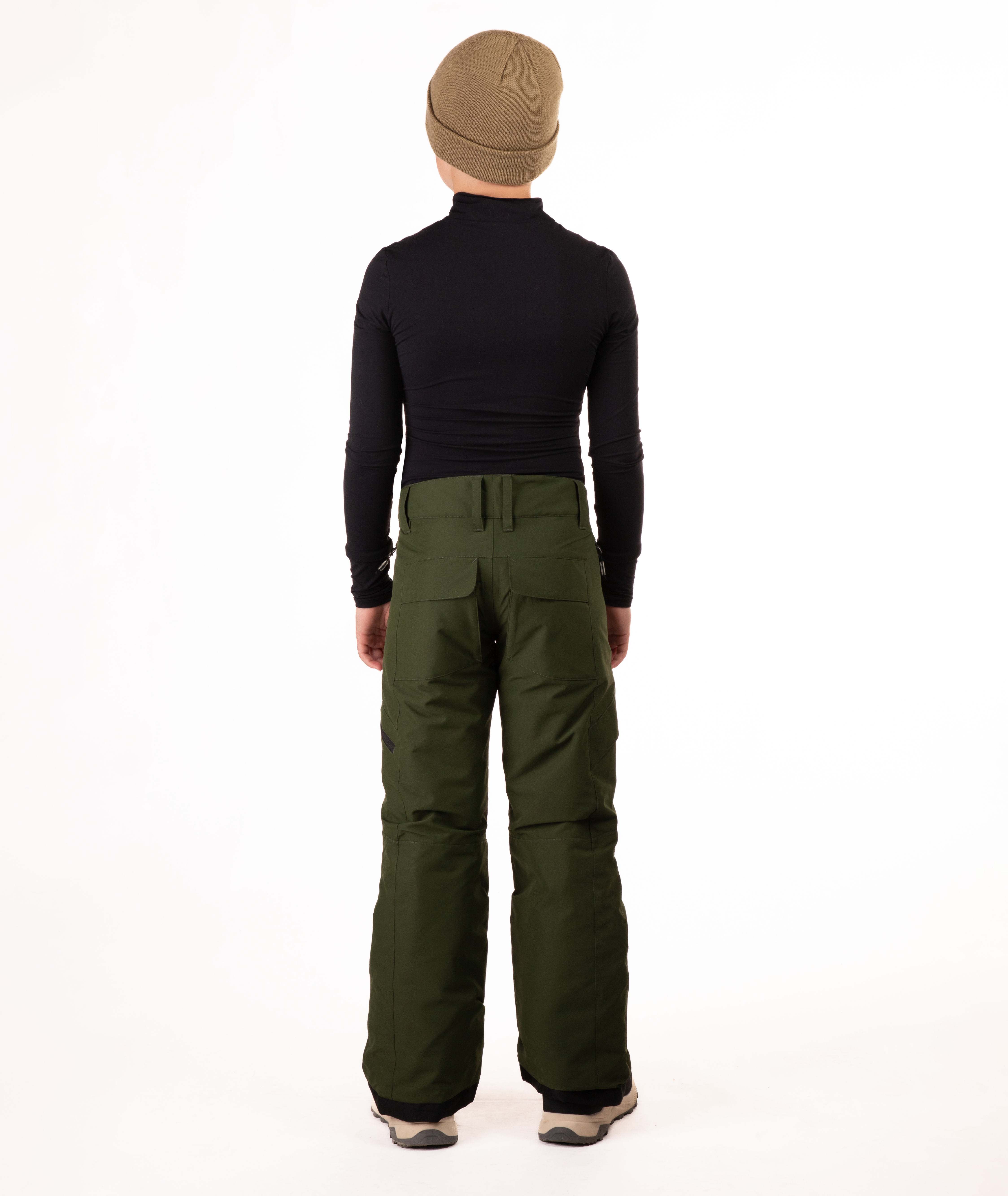back of youth boy wearing a black long-sleeve shirt and green snow pants on a white background
