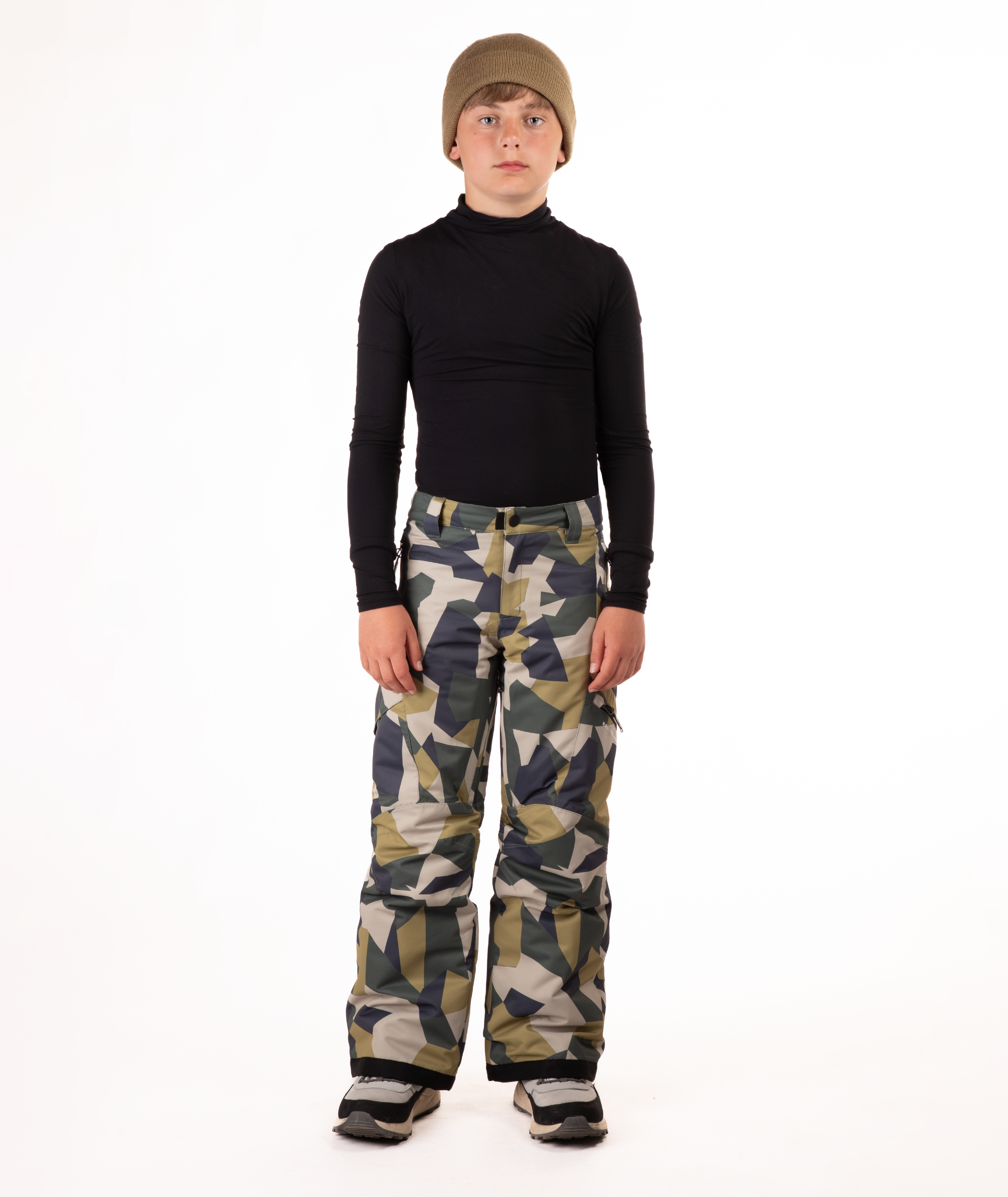 youth boy wearing a black long-sleeve shirt and camouflage snow pants on a white background