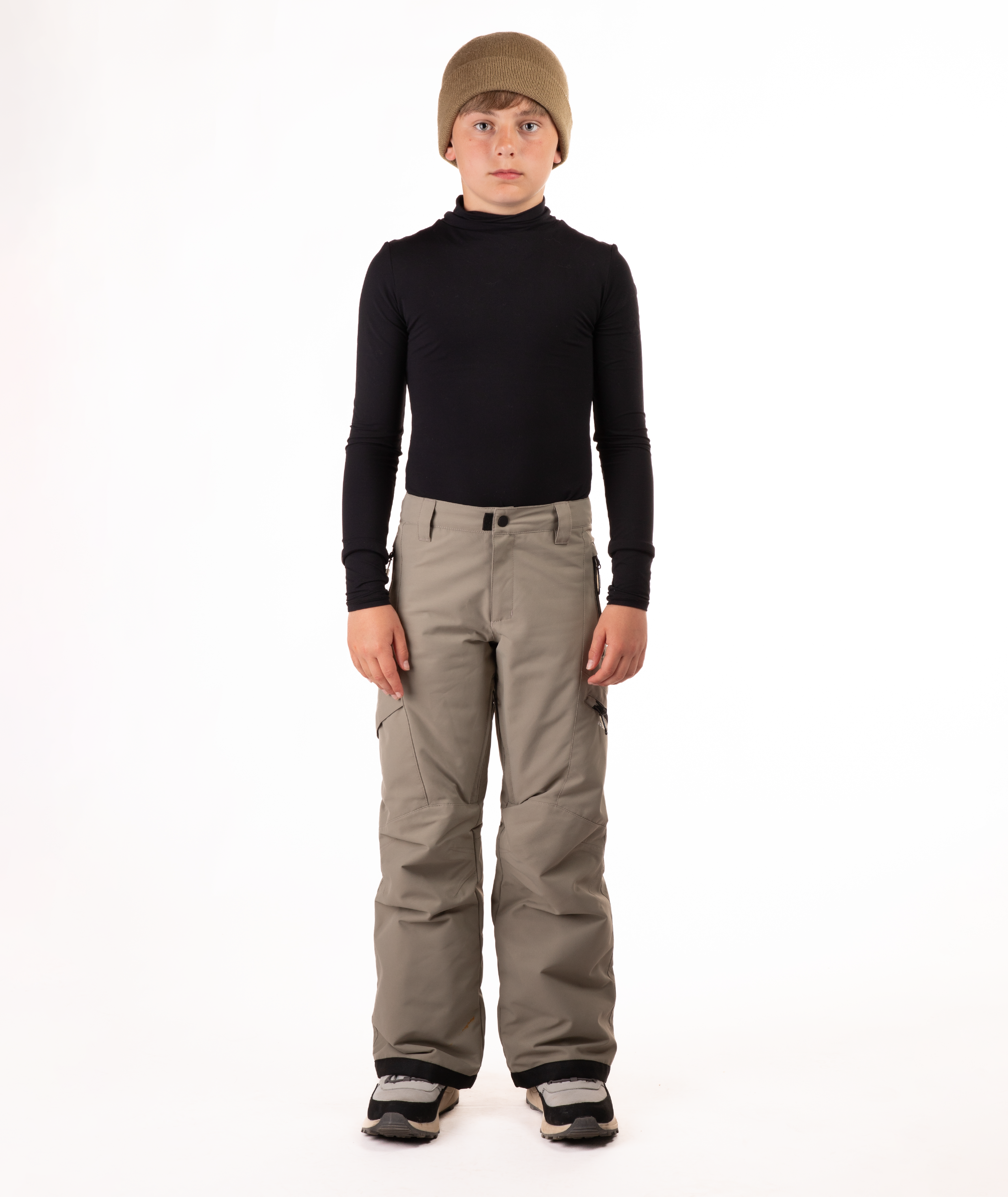 youth boy wearing a black long-sleeve shirt and beige snow pants on a white background