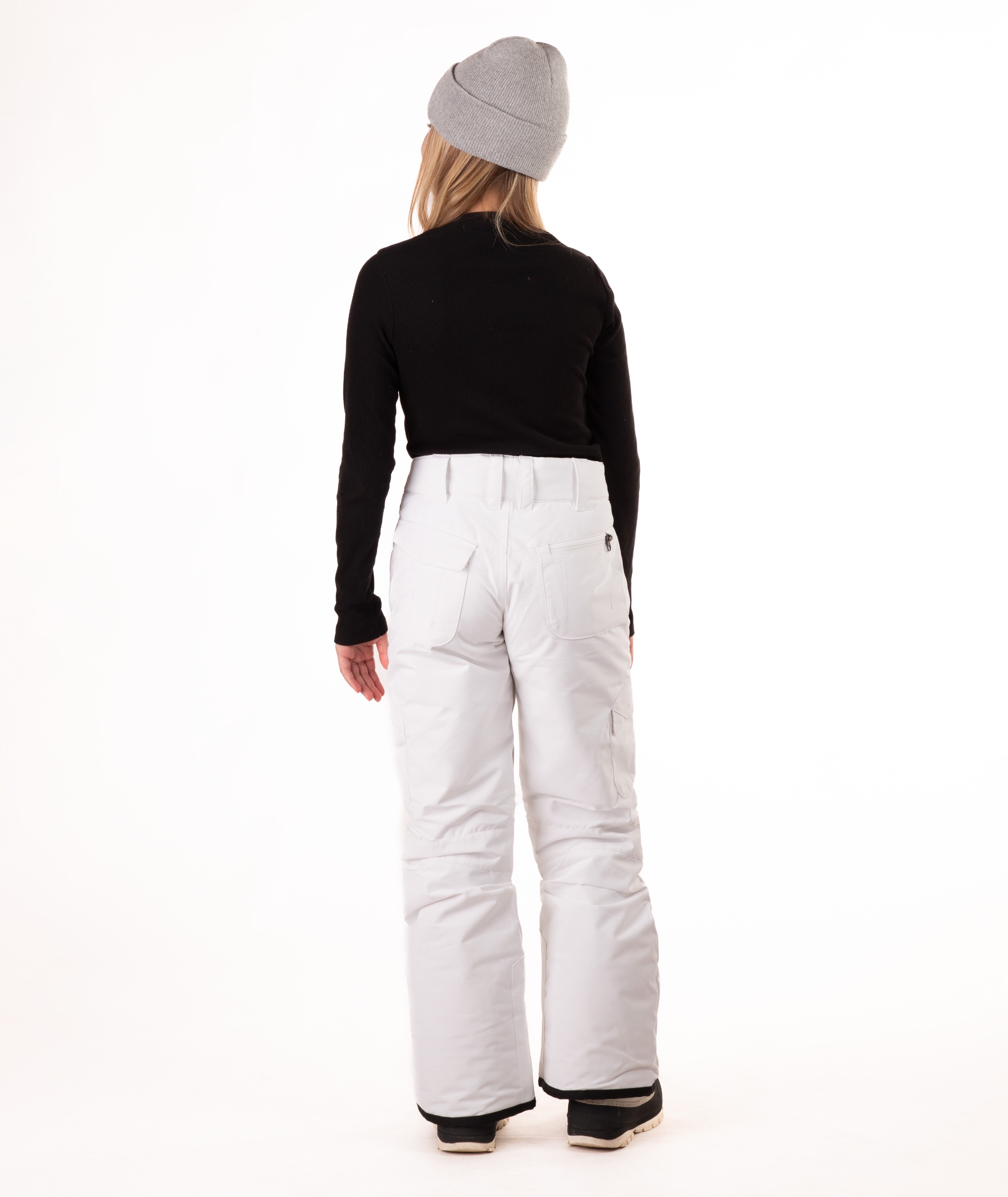 back of a girl wearing white snow pants and a black long-sleeve top on a white background
