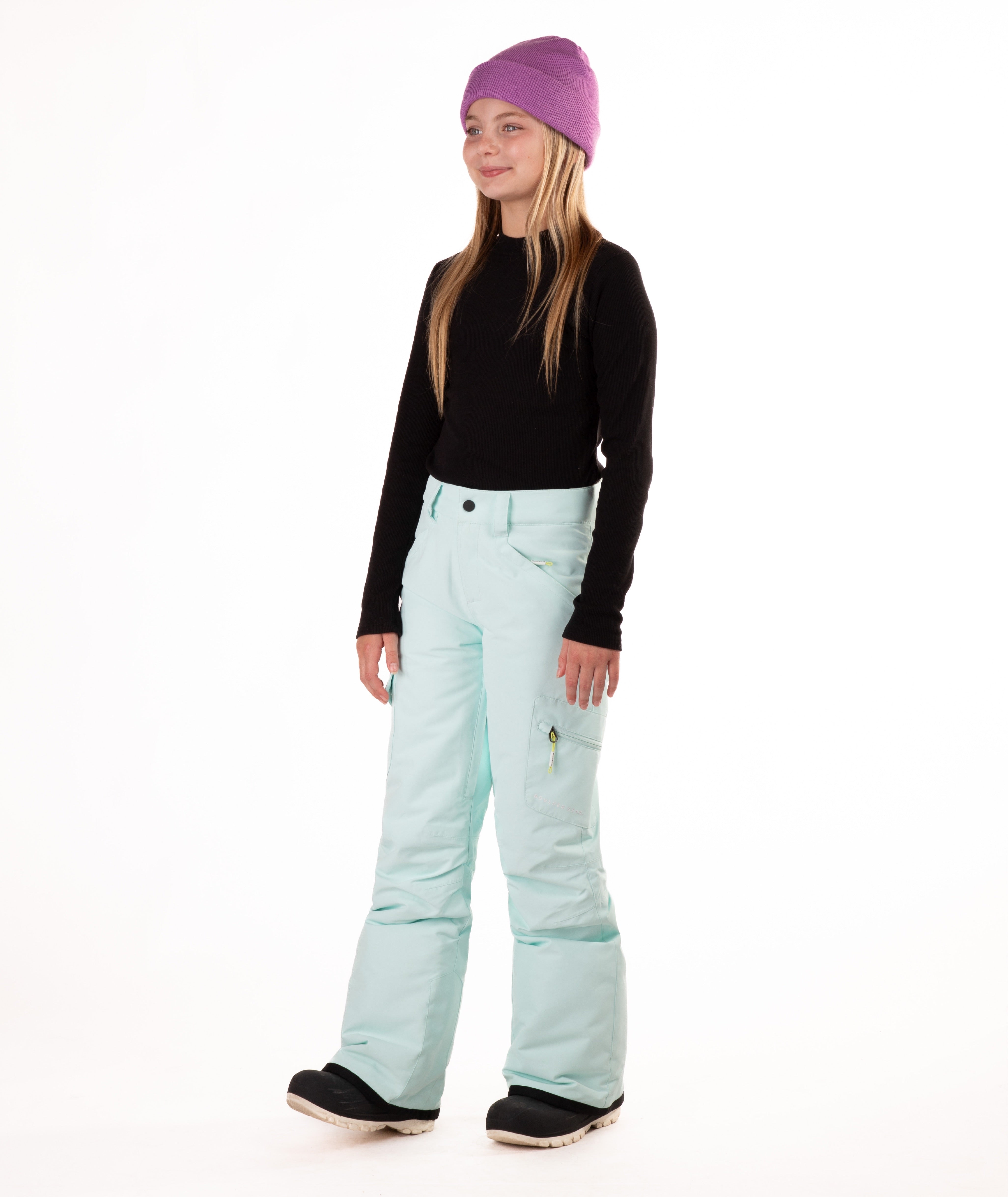 girl wearing light blue snow pants and a black long-sleeve top on a white background