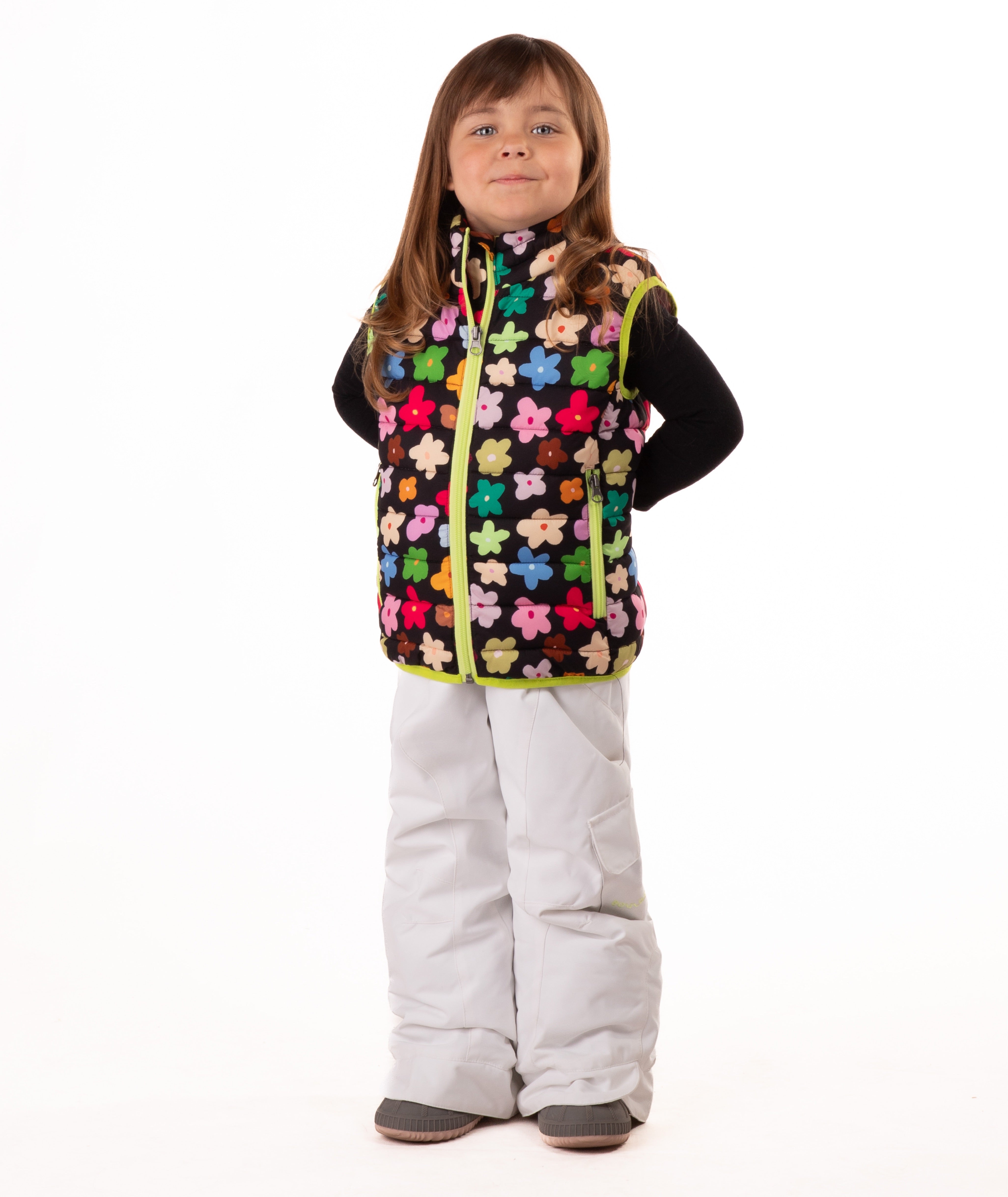 Child wearing multi colored flower print vest with yellow accents on a white background