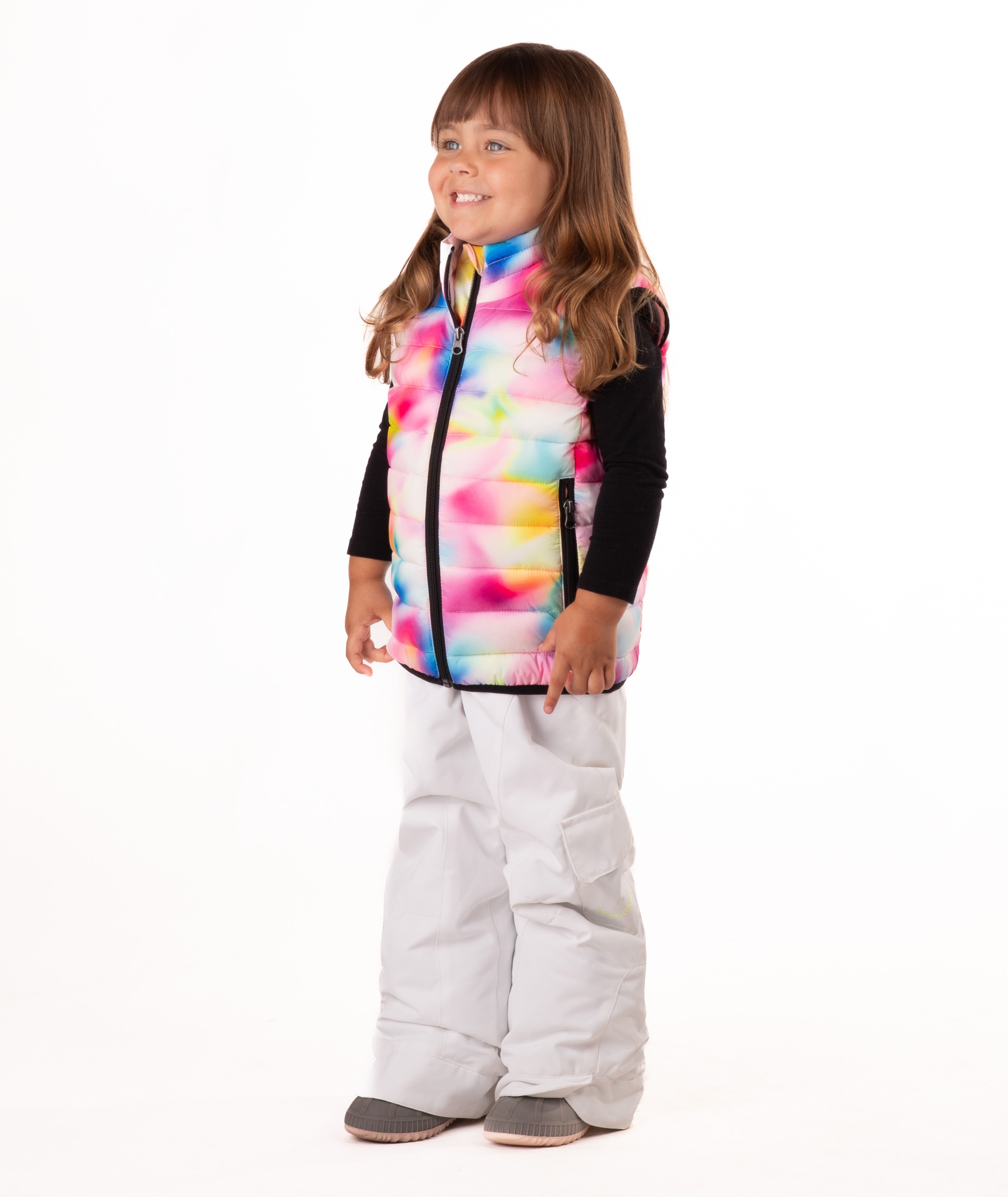 Child wearing multi colored abstract print vest with black accents on a white background