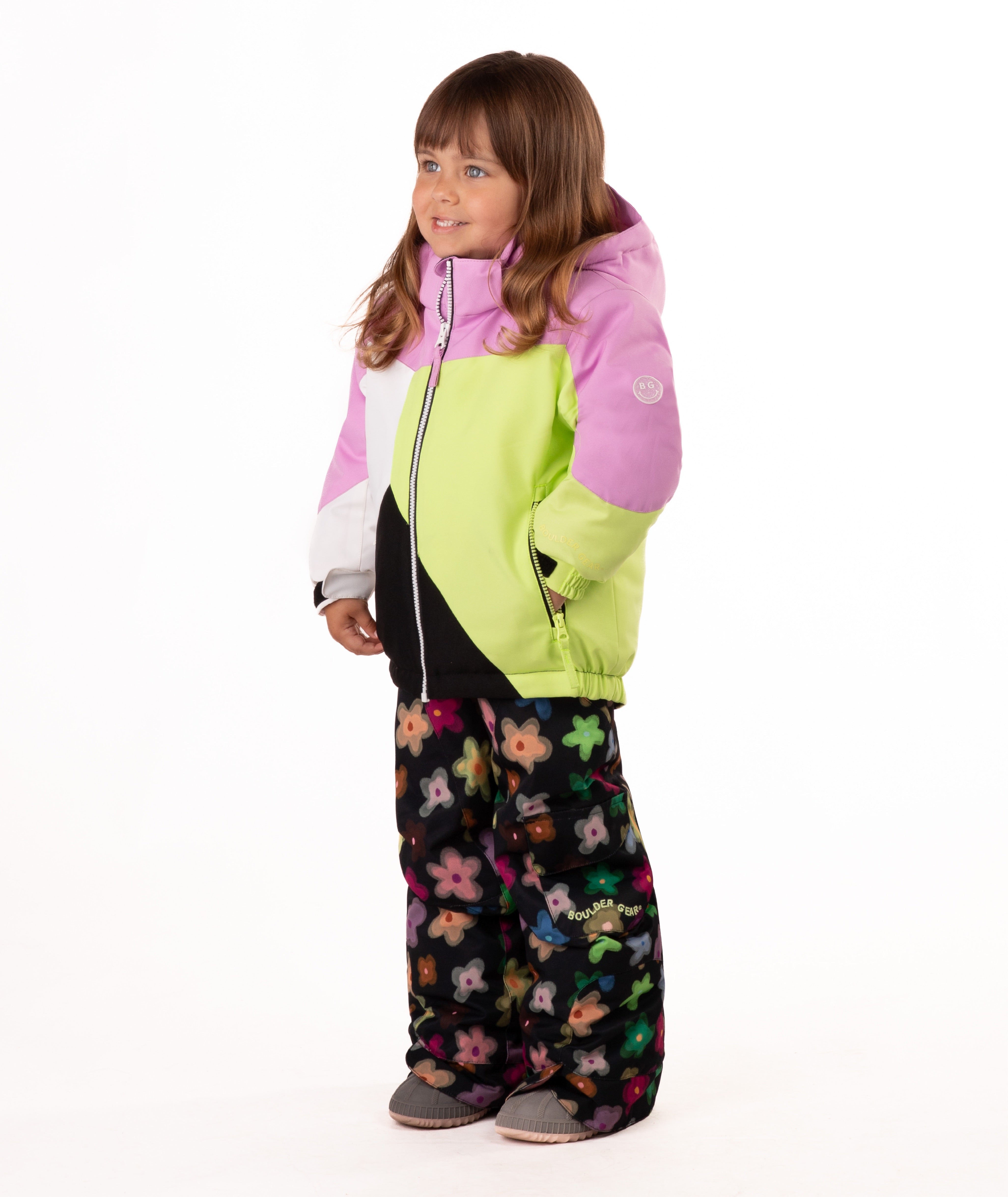 Child wearing a colorful jacket with pink, green, black, and white colors on a white background