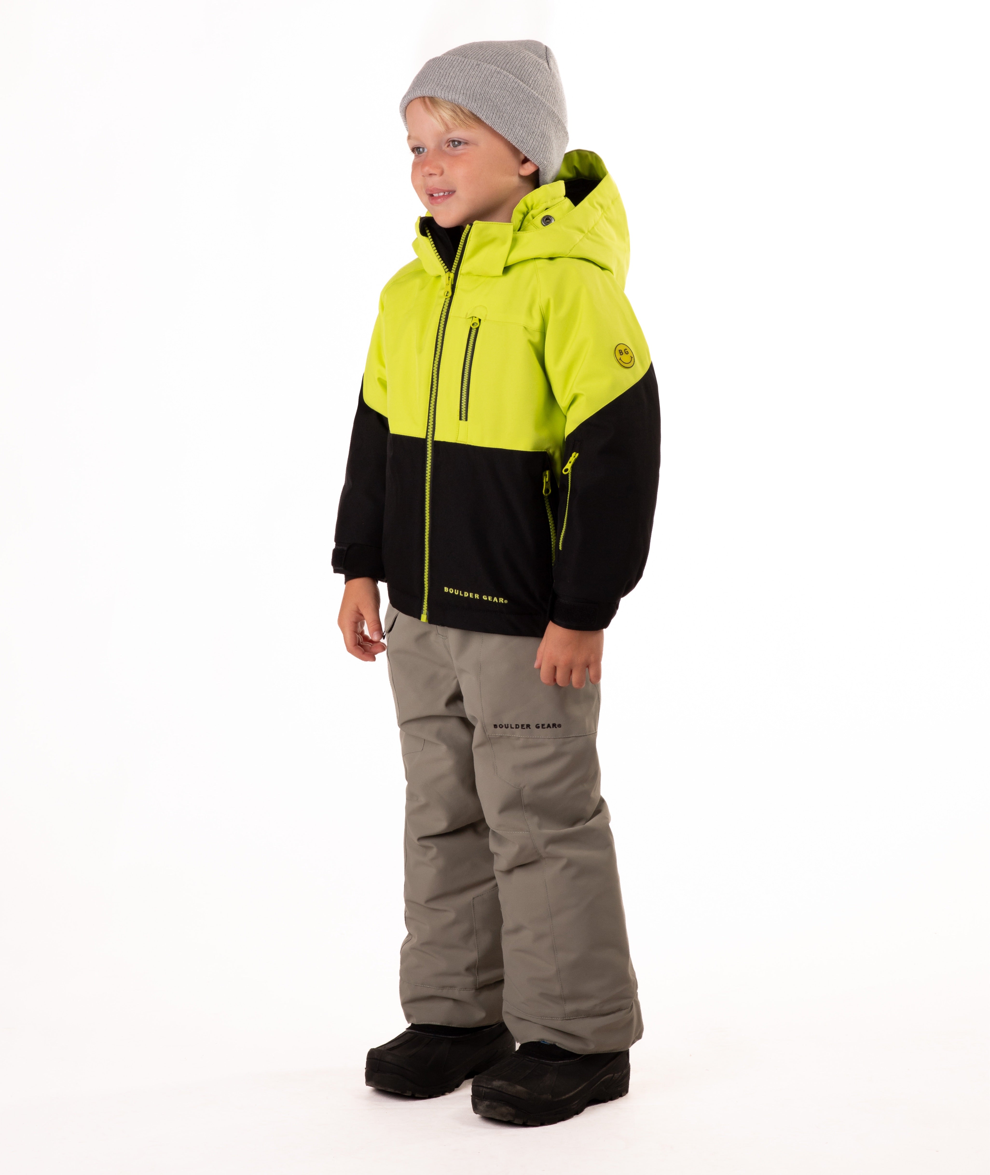 Child wearing a two-tone jacket with black on the bottom half and bright lime yellow top half on a white background showing hand pocket and sleeve pocket detail