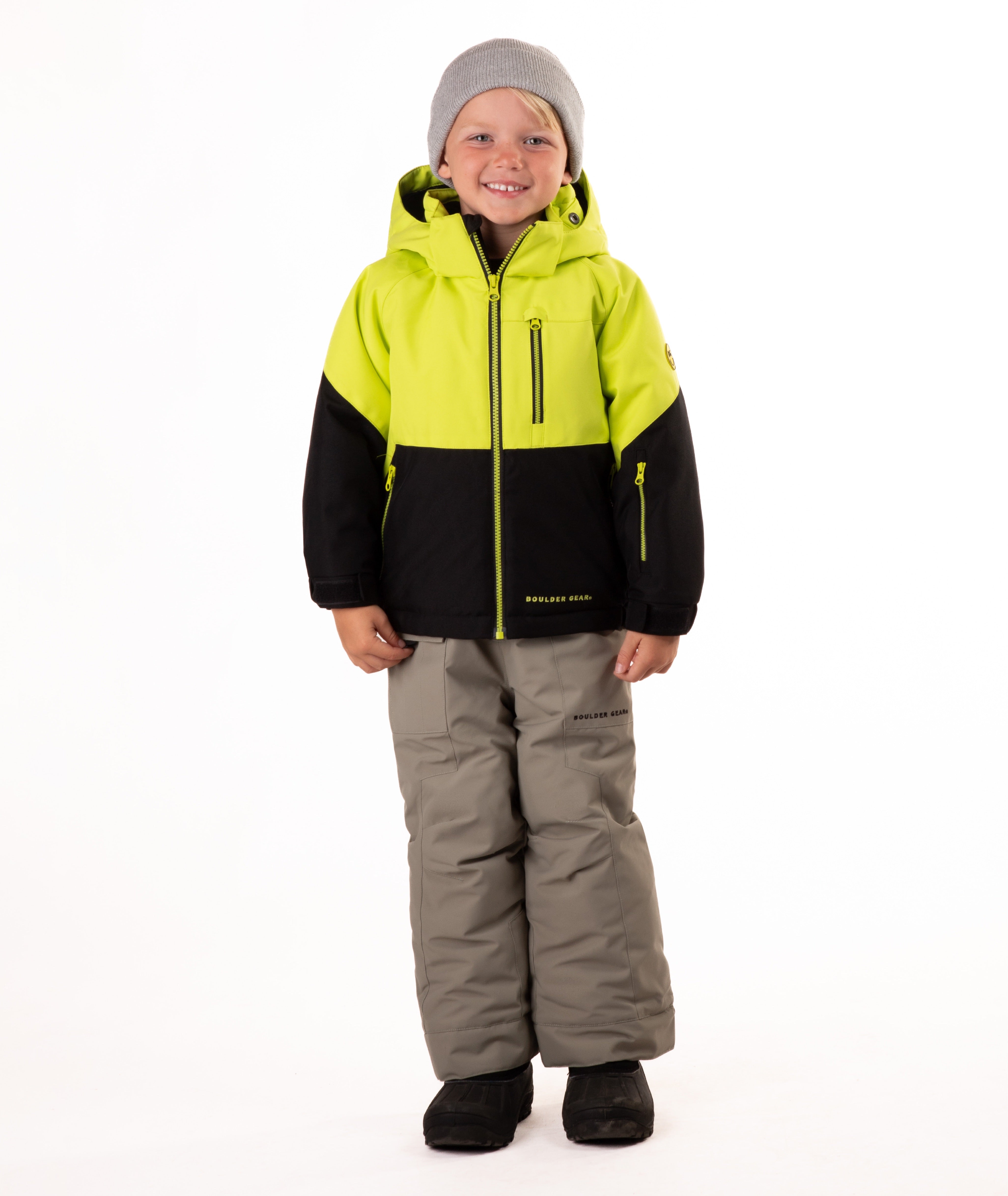 Child wearing a two-tone jacket with black on the bottom half and bright lime yellow top half on a white background