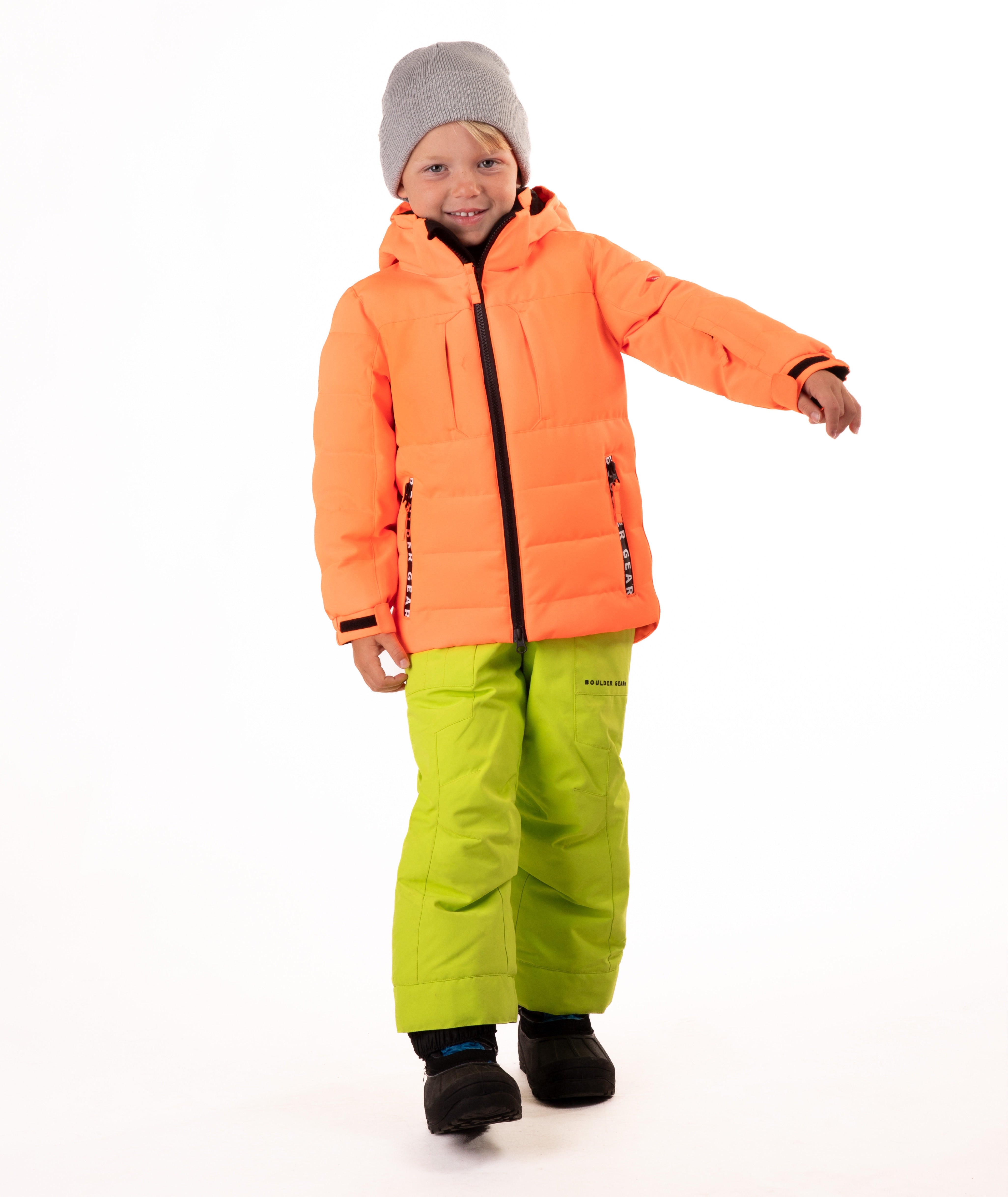 Child wearing a orange quilted winter jacket with chest pockets and hand-warmer pockets on a white background