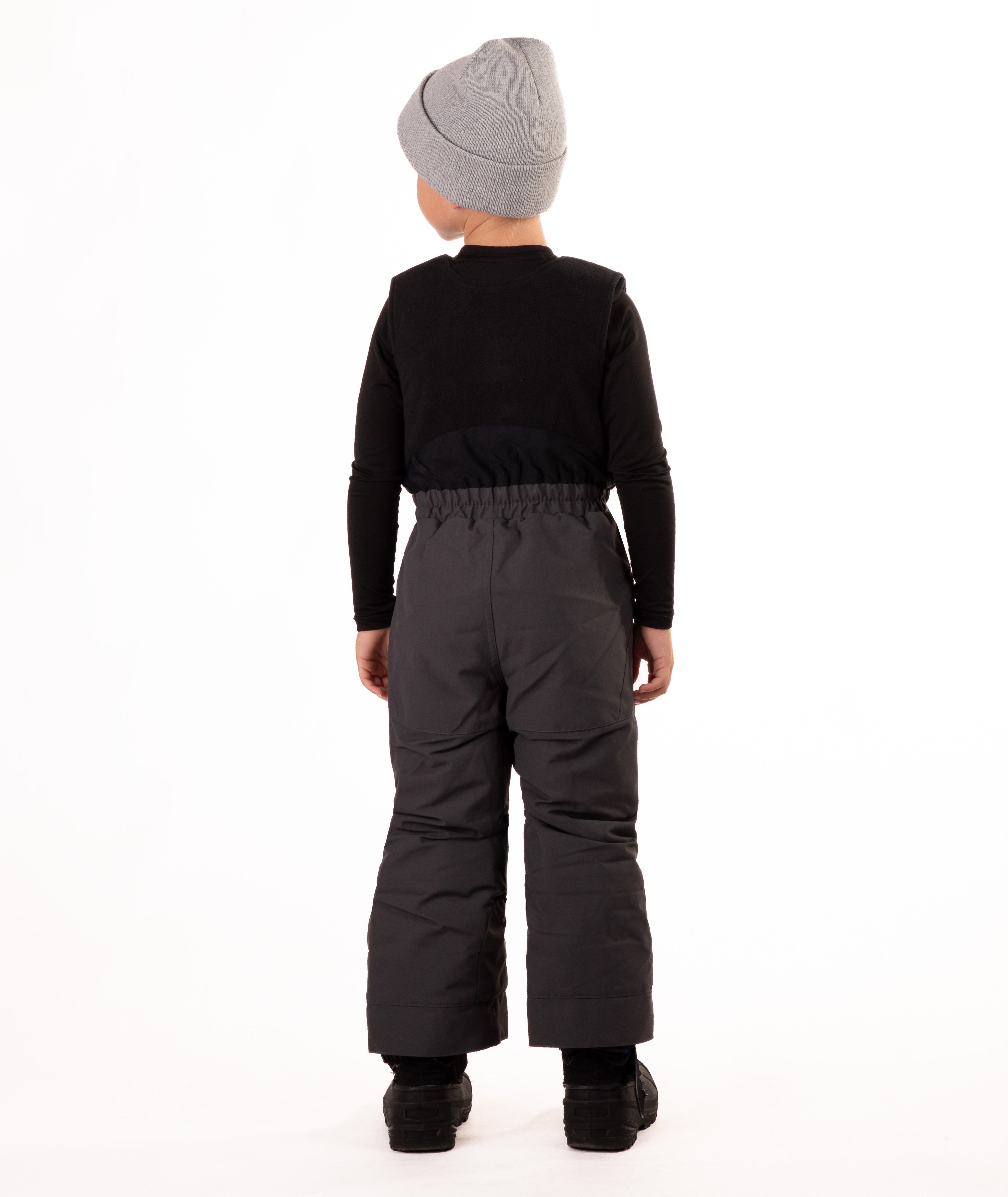 back of Child wearing dark gray snow bibs on a white background