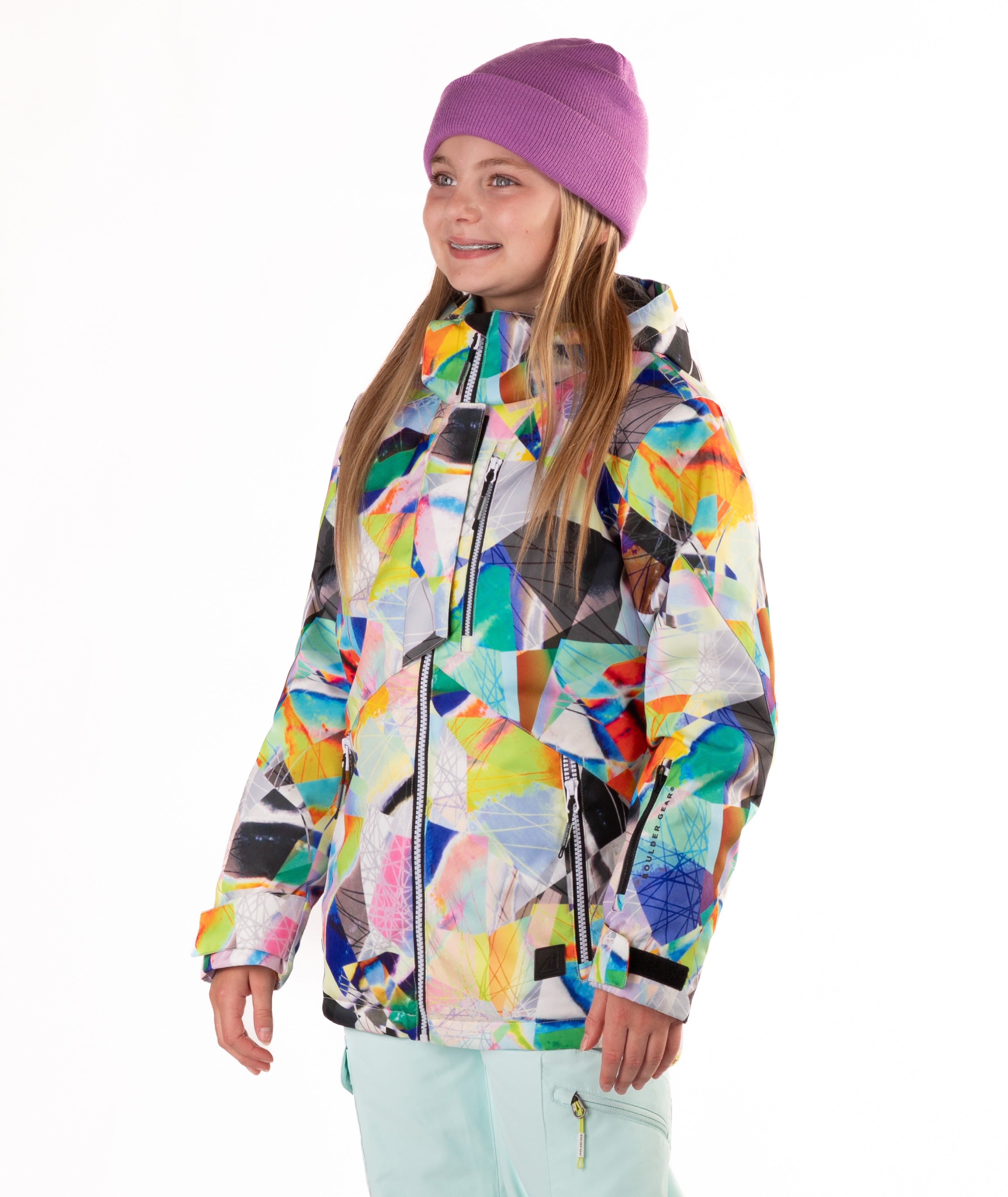 Youth girl wearing a colorful geometric-patterned jacket on a white background