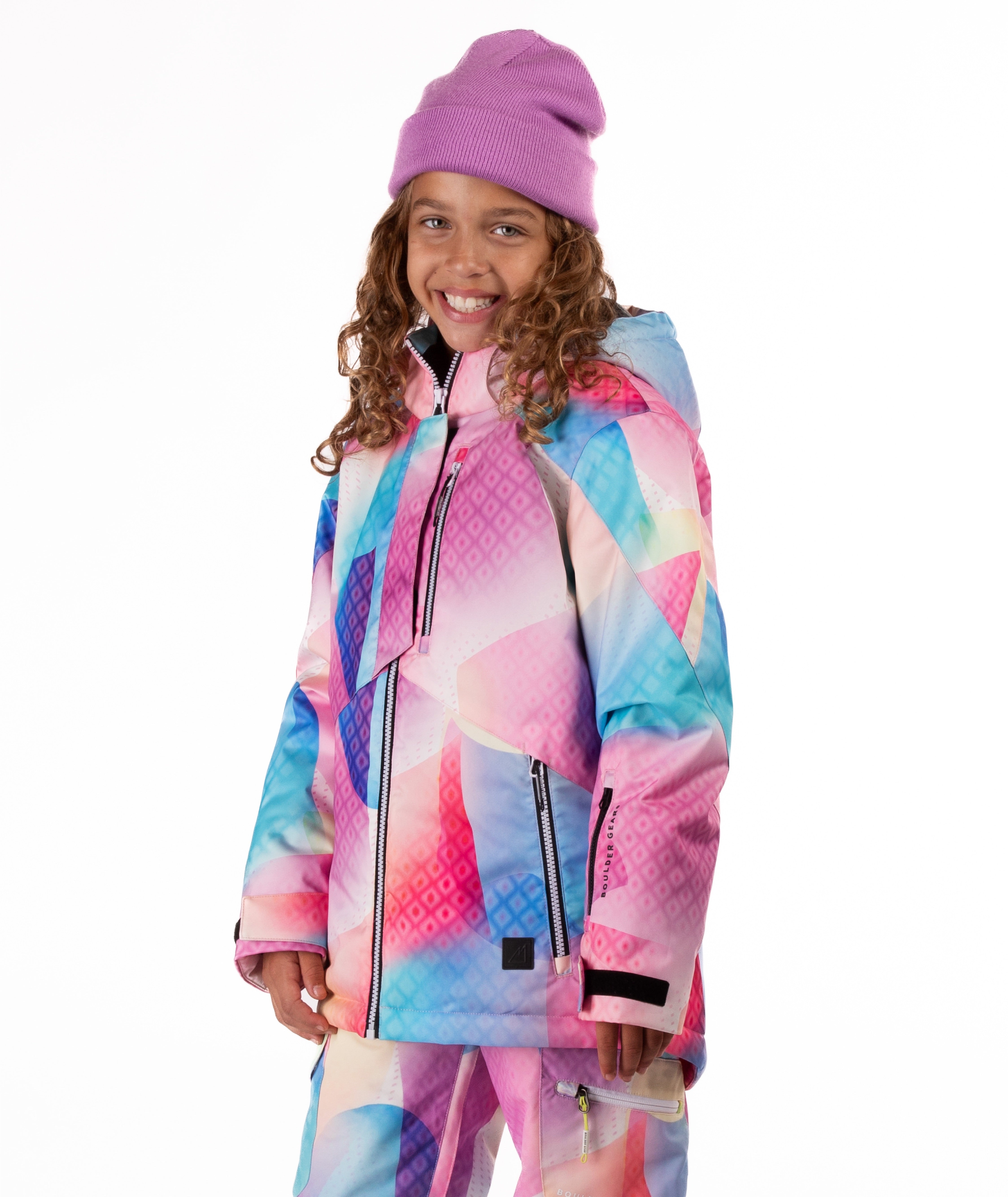 Youth girl wearing a colorful geometric print jacket on a white background