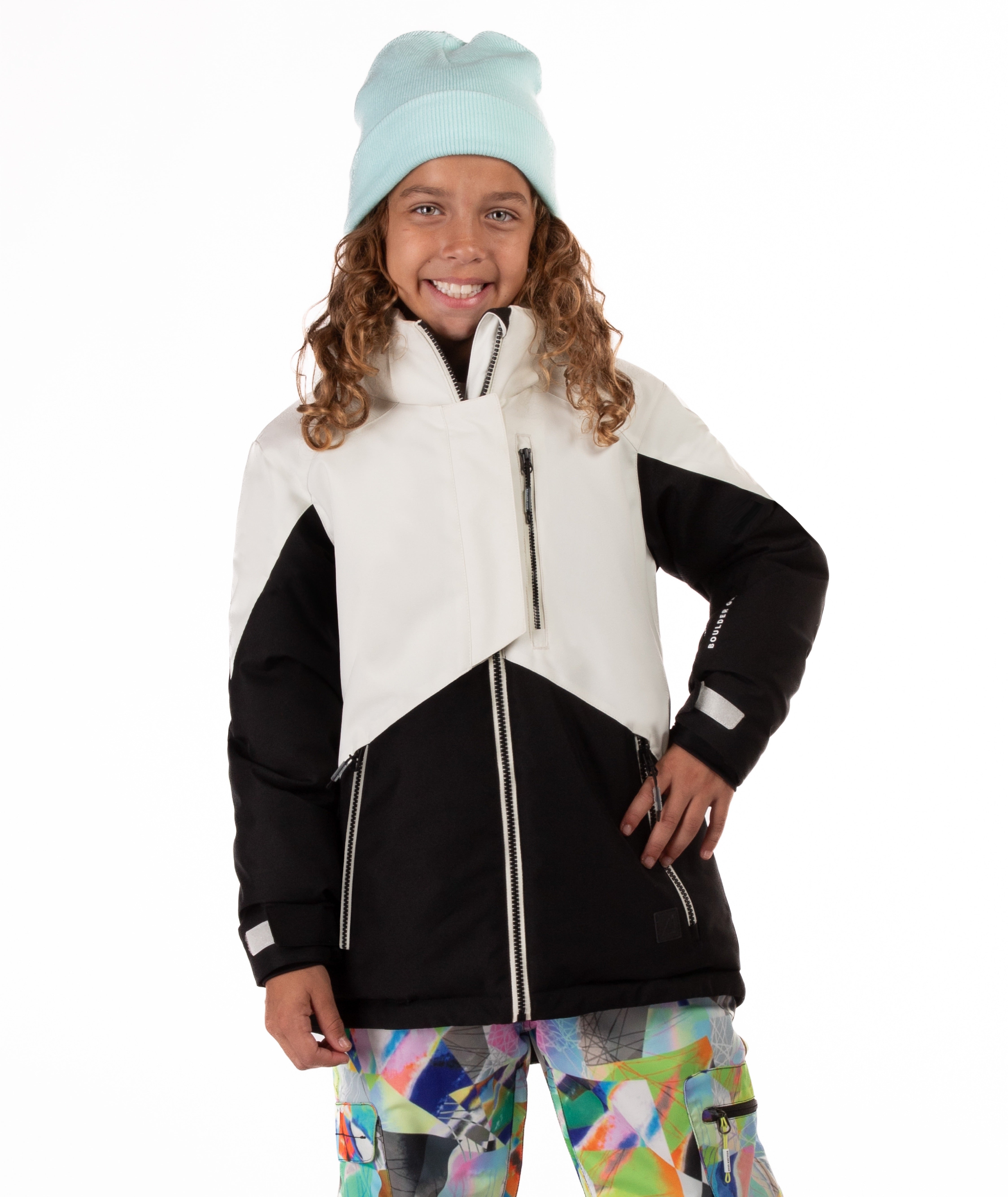 Youth girl wearing a black and white jacket with contrasting zippers on a white background